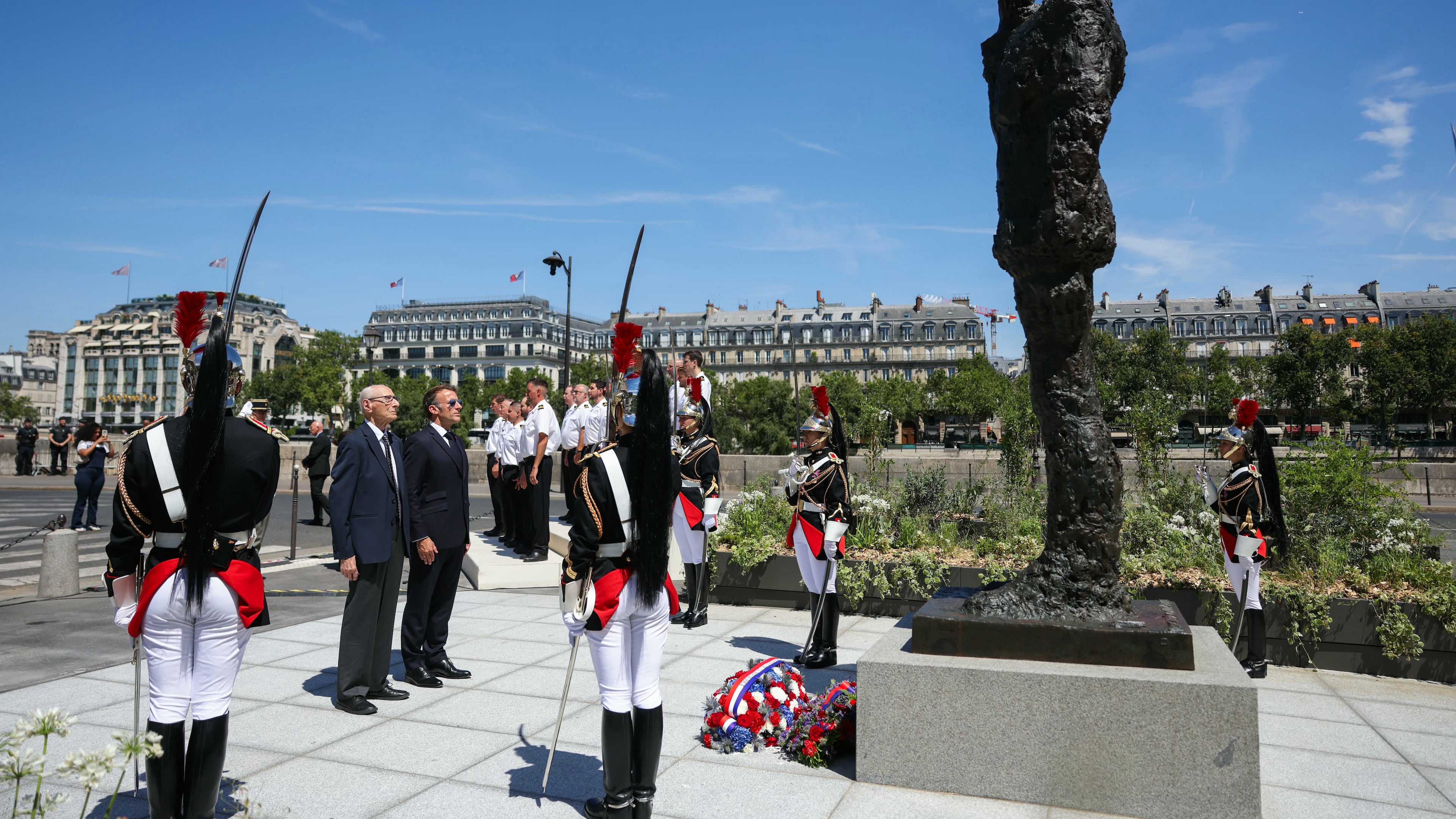 France's President Emmanuel Macron, center right, with Charles Dreyfus grandson of Alfred Dreyfus during a tribute ceremony to Captain Alfred Dreyfus on the first national day dedicated to the recognition of his innocence by the Court of Cassation in 1906, and the fight against the resurgence of antisemitism, 120 years later, on the Ile de la Cite near the Cour de Cassation in Paris, Sunday, July 12, 2026. (Thomas Samson/Pool Photo via AP)