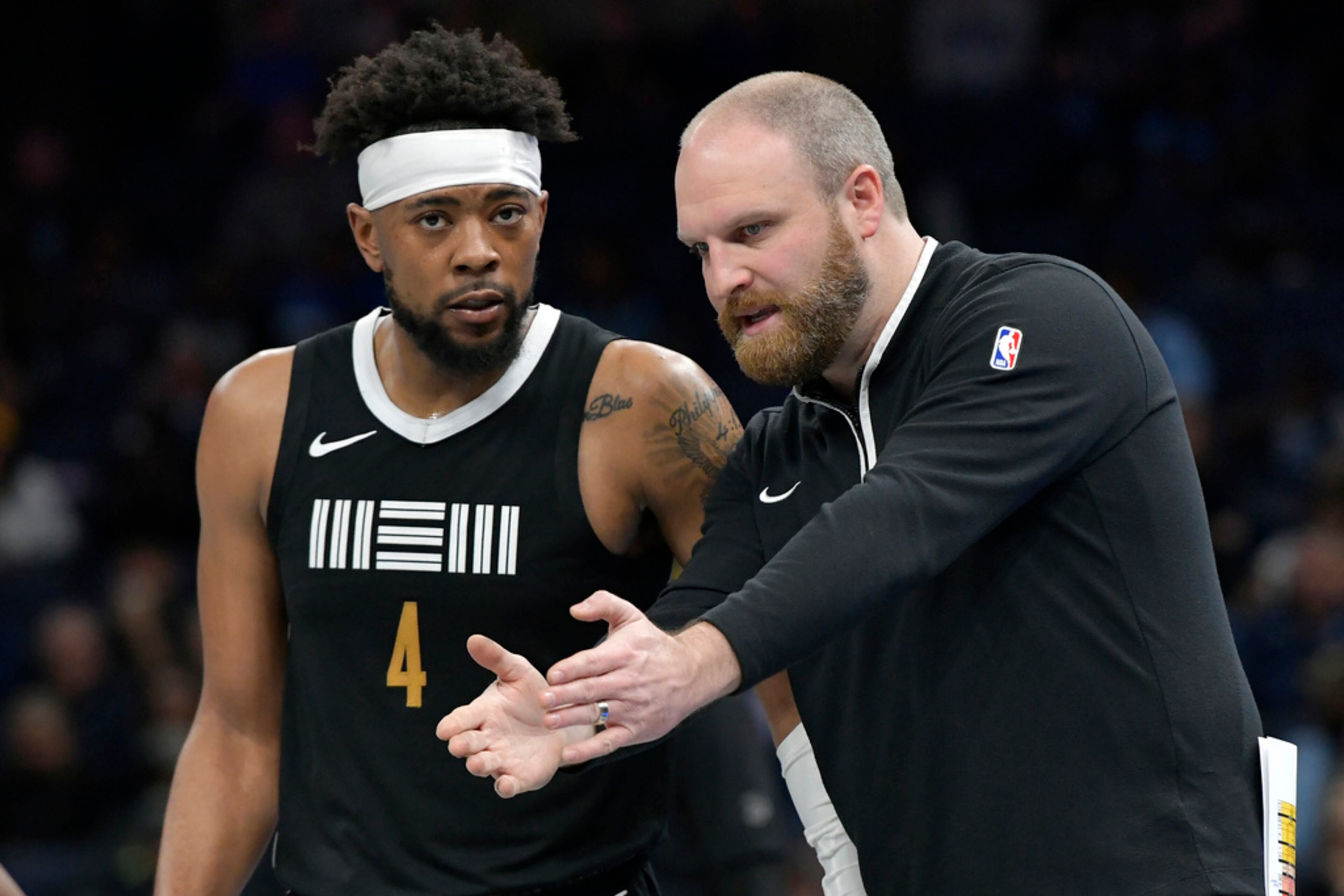 Memphis Grizzlies coach Taylor Jenkins talks with guard Jordan Goodwin (4) during the first half of the team's NBA basketball game against the Atlanta Hawks on Friday, March 8, 2024, in Memphis, Tenn. (AP Photo/Brandon Dill)