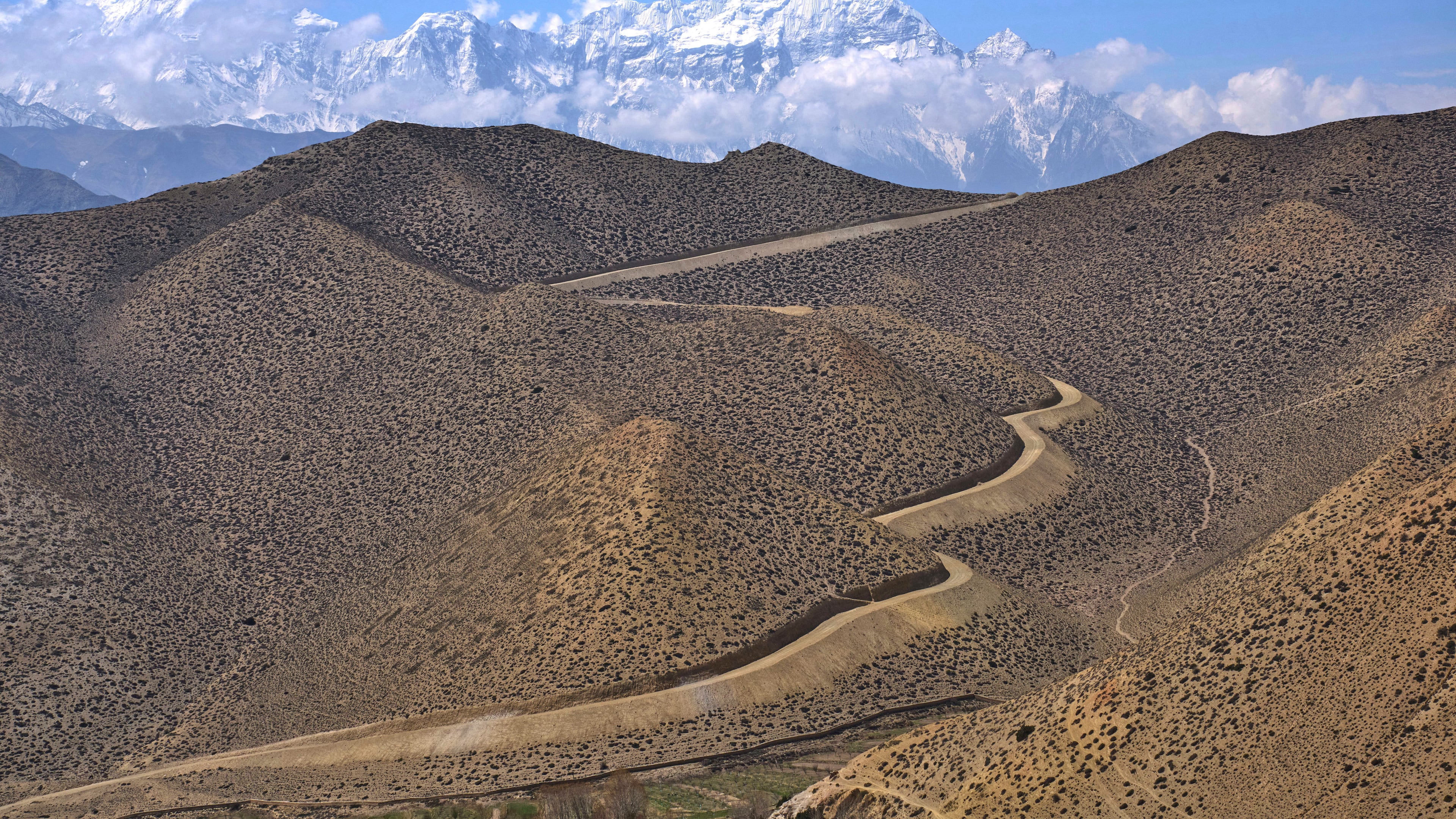 FILE- A dirt road through barren mountains in the Mustang region, 462 kilometers (288 miles) west of Kathmandu, Nepal, Thursday, April 17, 2025. (AP Photo/Niranjan Shrestha, File)