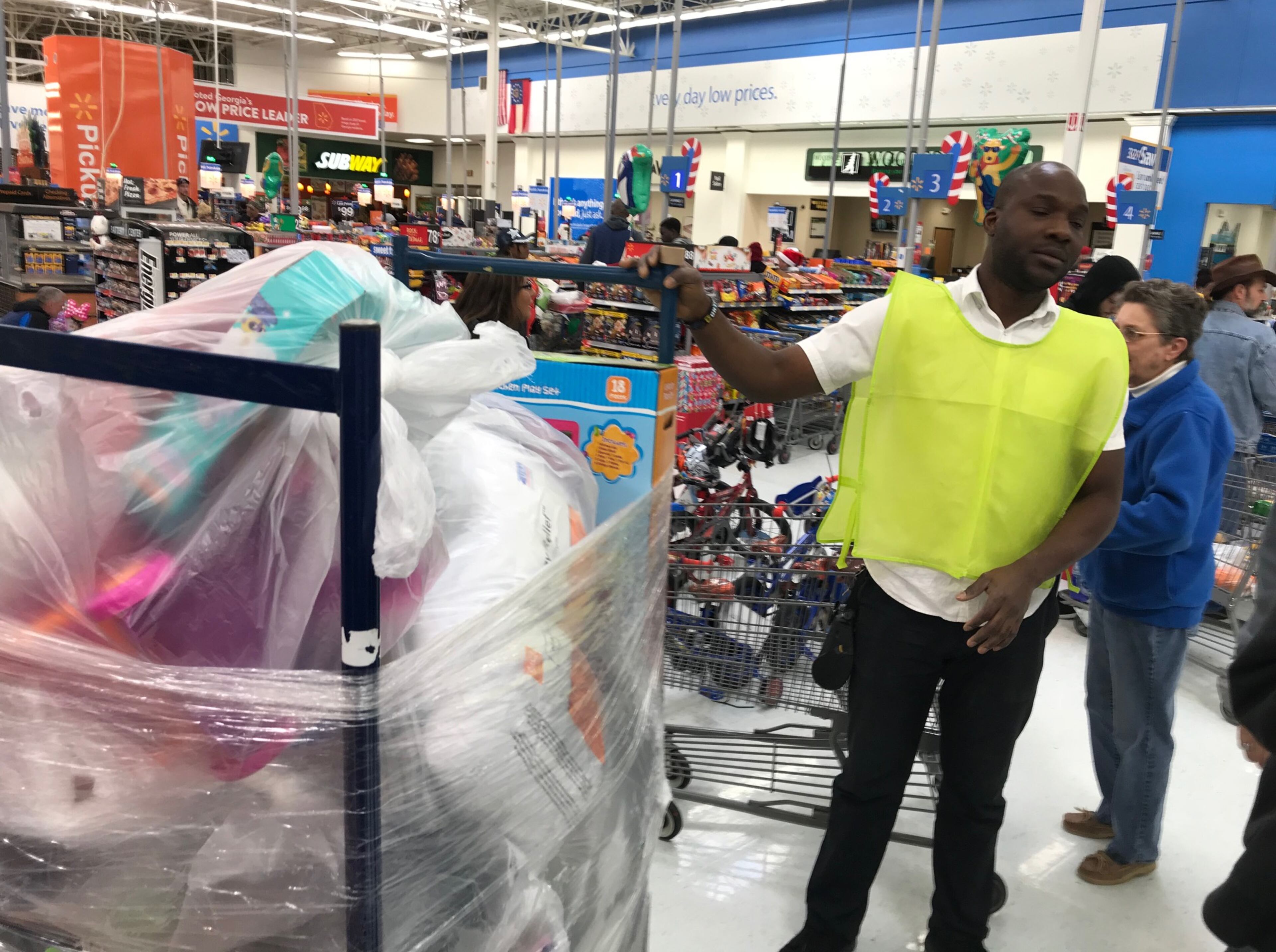 Ken Ribo, a Wal-Mart employee, takes gifts to a tractor-trailer to be sorted. CREDIT: Rodney Ho/rho@ajc.com