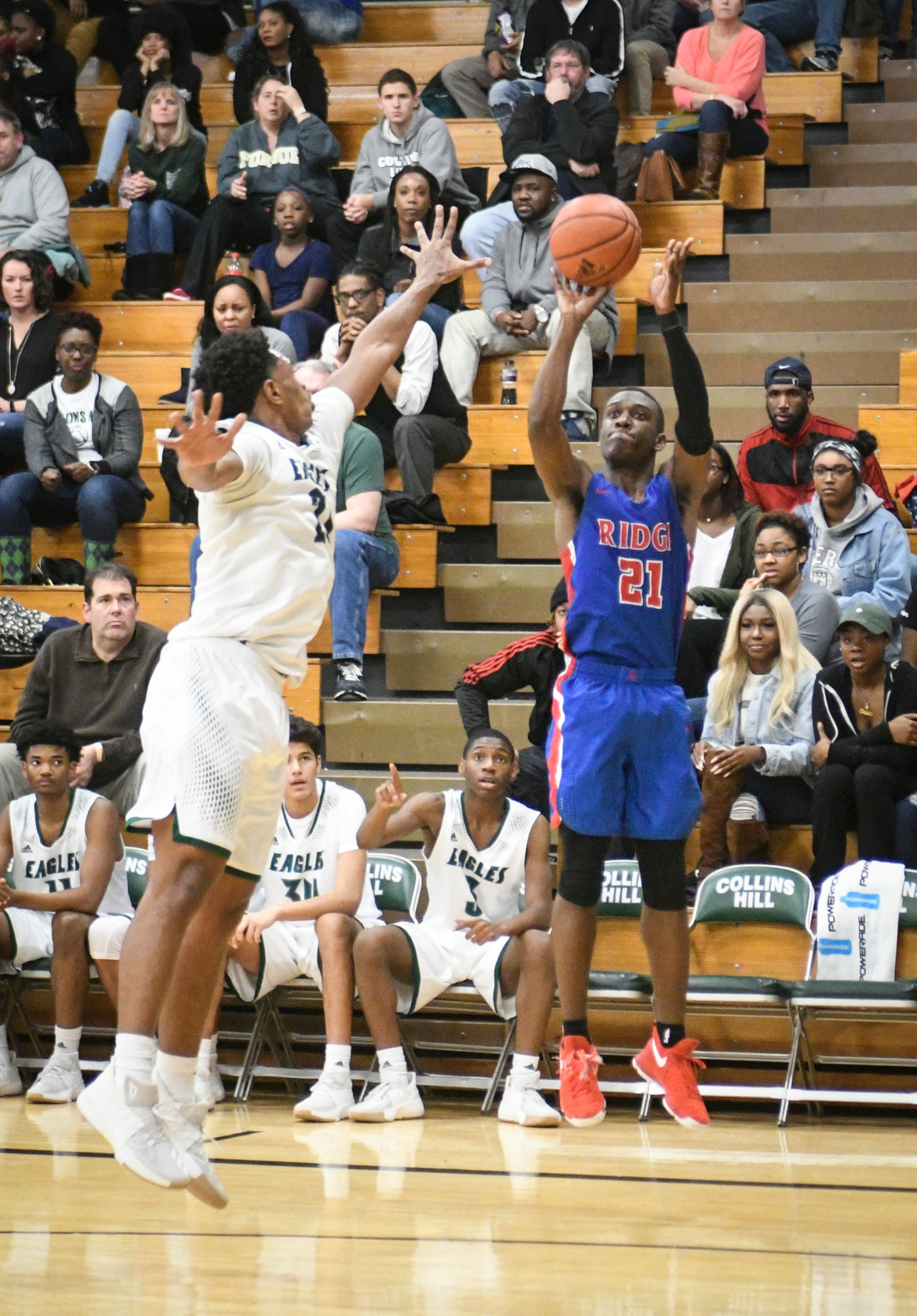 Peachtree Ridge guard Hirum Maxey (21) shoots as Collins Hill forward Chris Parks, left, during a high school basketball game on Friday, Jan.12, 2018, in Suwanee, Ga. (John Amis)