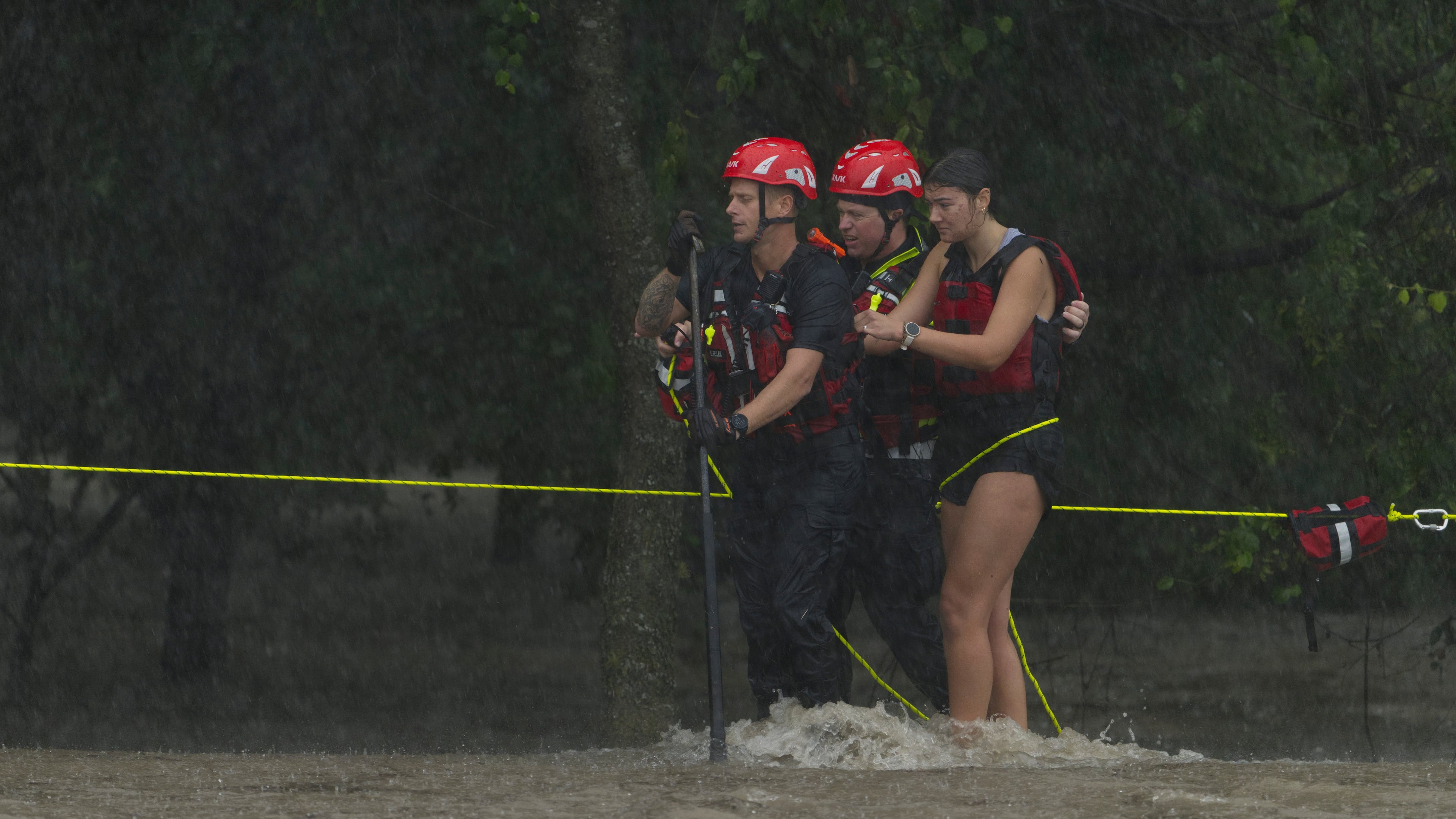 Members of the Boerne Fire Dept. rescue a woman from flood waters on Wednesday, July 15, 2026, in Boerne, Texas. (AP Photo/Darren Abate)
