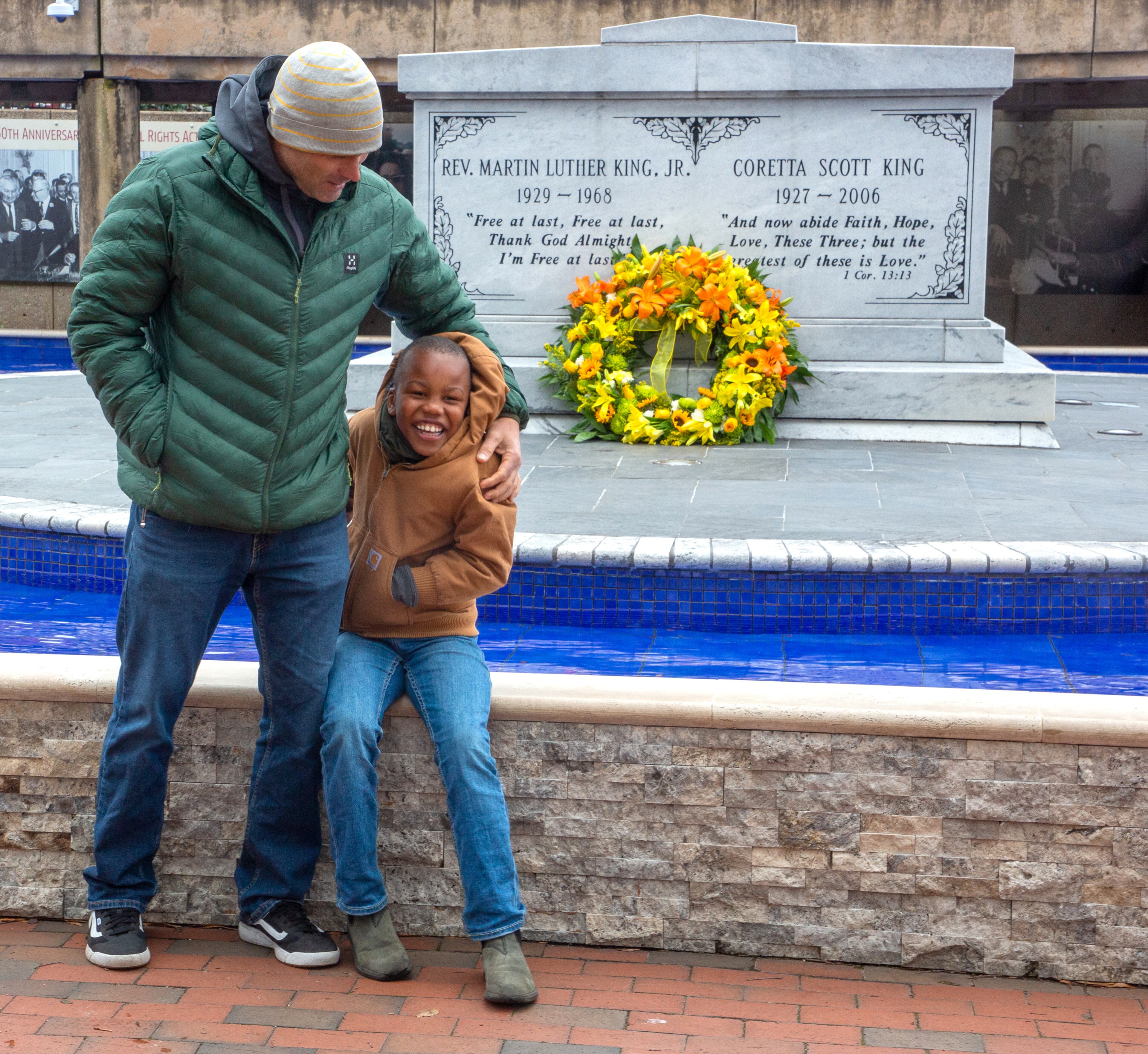 Anders Frank tries to get his son Malik, 7, to pose for a picture in front of the tomb of the Rev. Martin Luther King Jr. and Coretta Scott King at the King Center on Monday, January 17, 2022. (Photo: Steve Schaefer for The Atlanta Journal-Constitution)