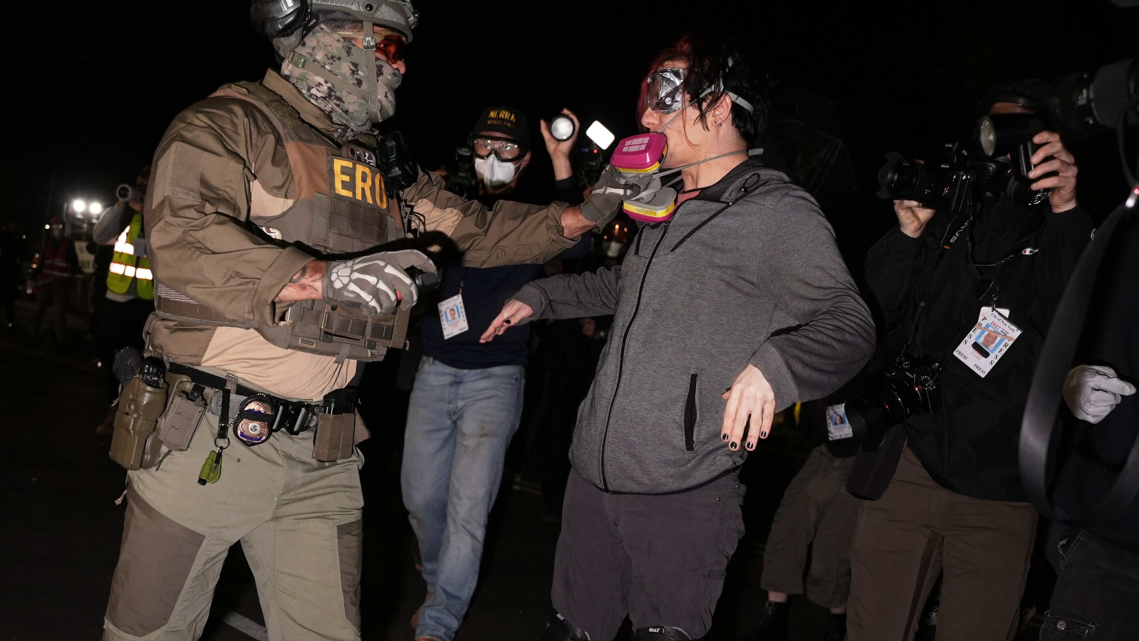 A federal immigration officer pulls the respirator mask from a protester outside Delaney Hall detention center Thursday, May 28, 2026, in Newark, N.J. (AP Photo/Angelina Katsanis)