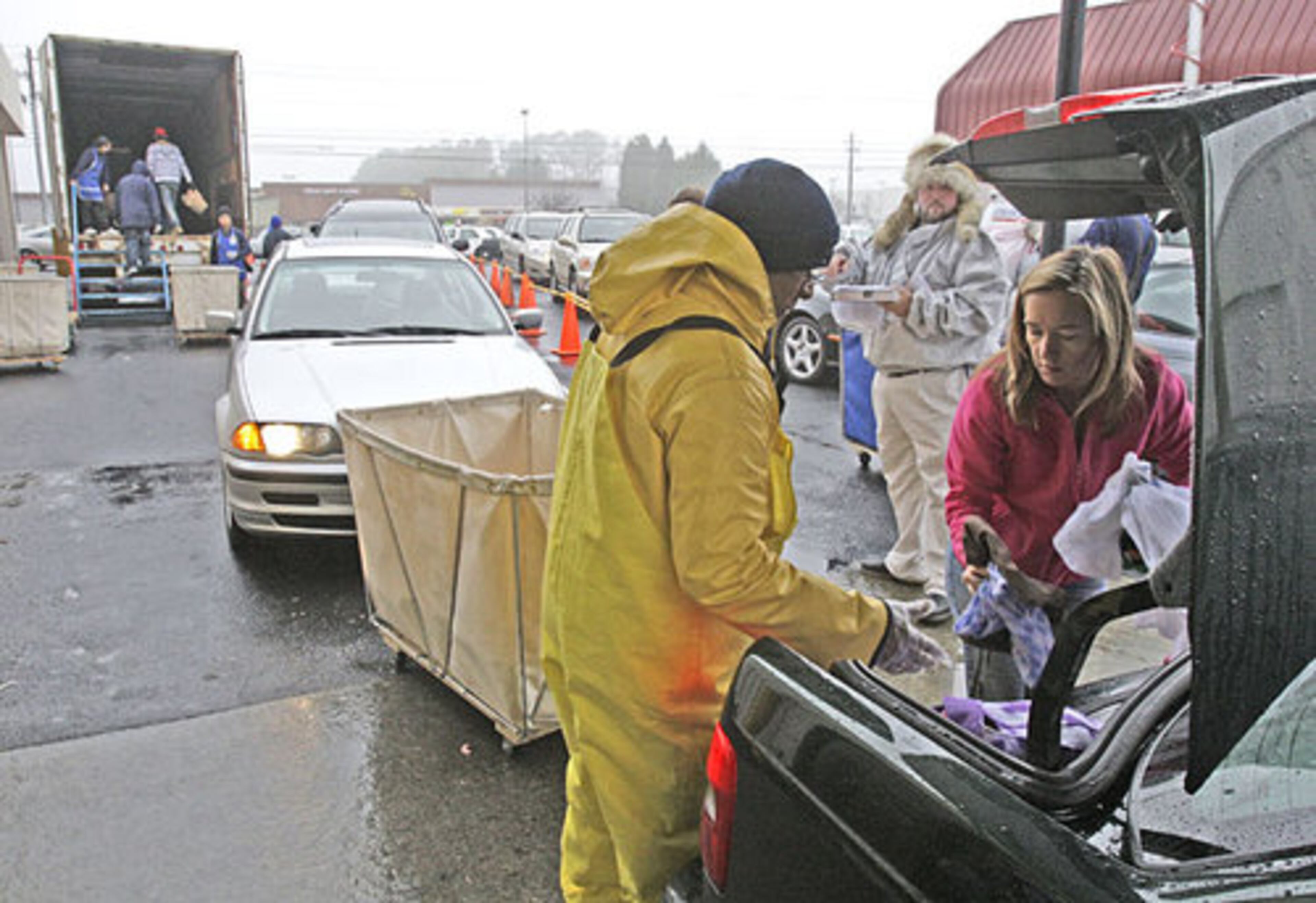 Goodwill employee Jorge Evans (left) helps Penelope Mason of Alpharetta unload her donations.