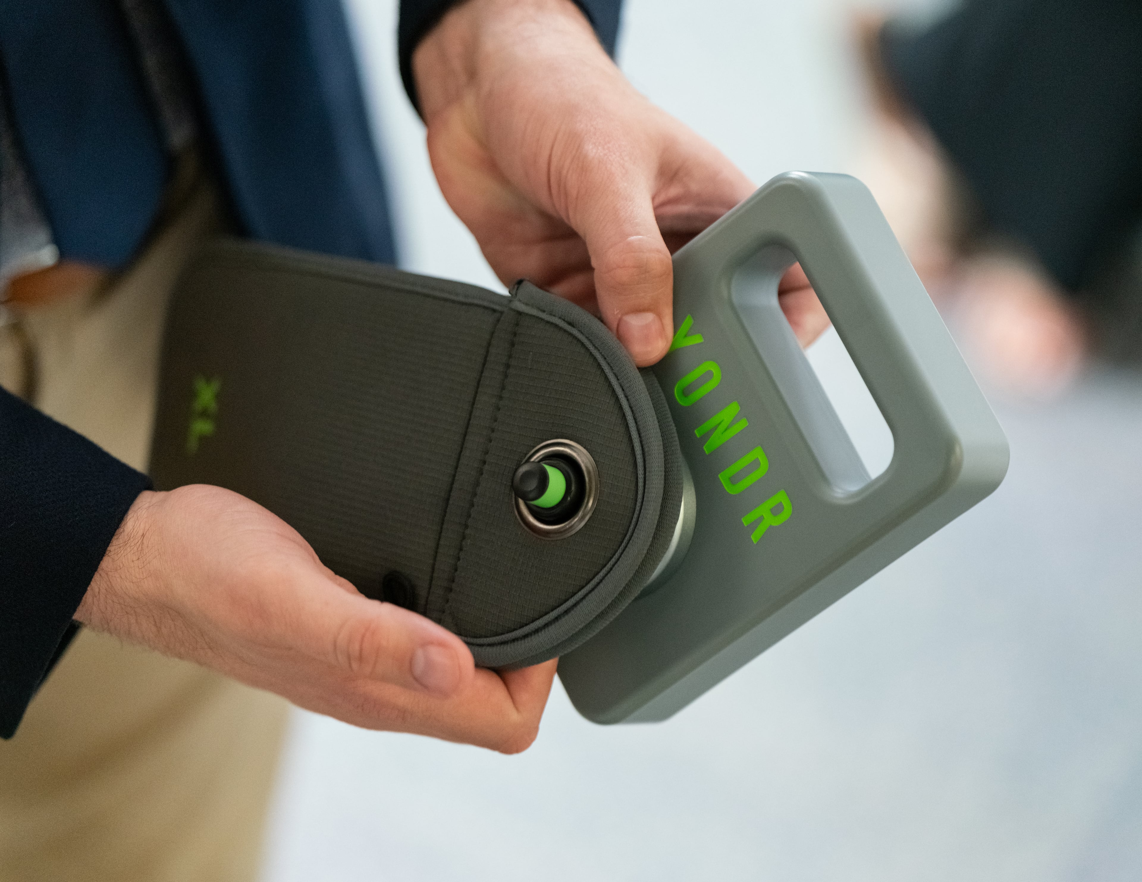 A school administration employee demonstrates the use of the phone locking bags to be used in the schools. The Marietta city school board unanimously passed a ban on cellphones for middle school students last year. (Ben Hendren for The Atlanta Journal-Constitution)