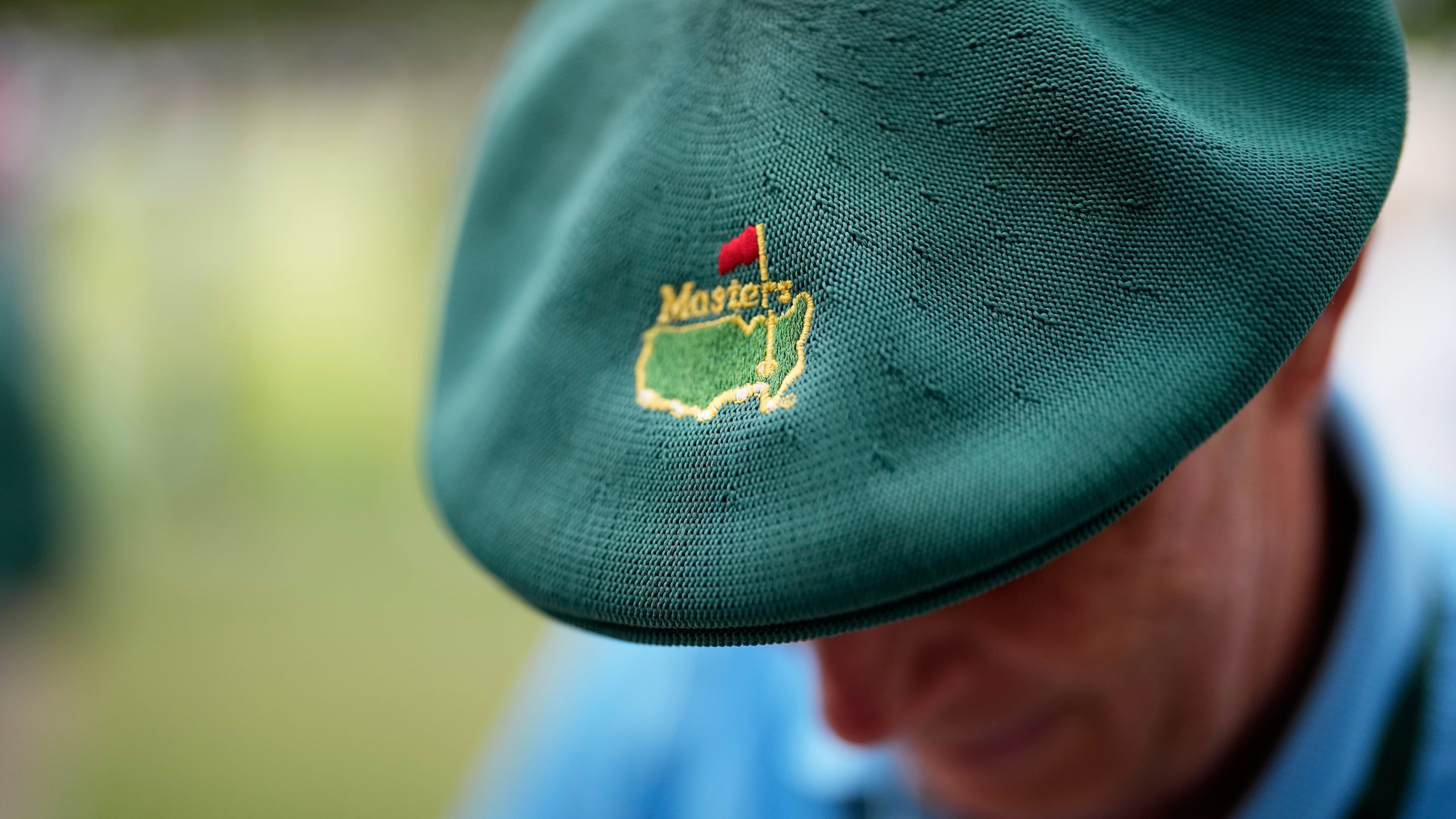 A patron sports a green Masters beret while attending a practice round ahead at the Augusta National Golf Club, in Augusta, Ga. , Monday, April 6, 2026. (AP Photo/David J. Phillip)