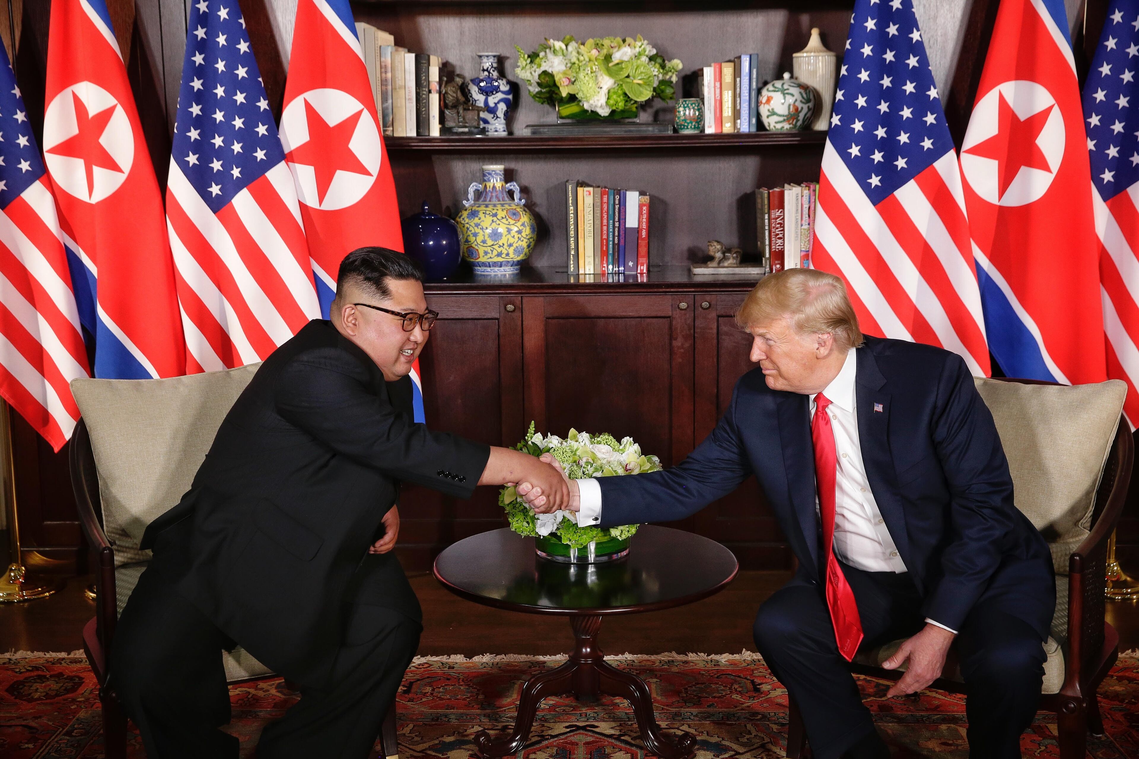SINGAPORE - JUNE 12: In this handout photo, North Korean leader Kim Jong-un (L) shakes hands with U.S. President Donald Trump during their historic U.S.-DPRK summit at the Capella Hotel on Sentosa island on June 12, 2018 in Singapore. U.S. President Trump and North Korean leader Kim Jong-un held the historic meeting between leaders of both countries on Tuesday morning in Singapore, carrying hopes to end decades of hostility and the threat of North Korea's nuclear program. (Photo by Kevin Lim/THE STRAITS TIMES/Handout/Getty Images)