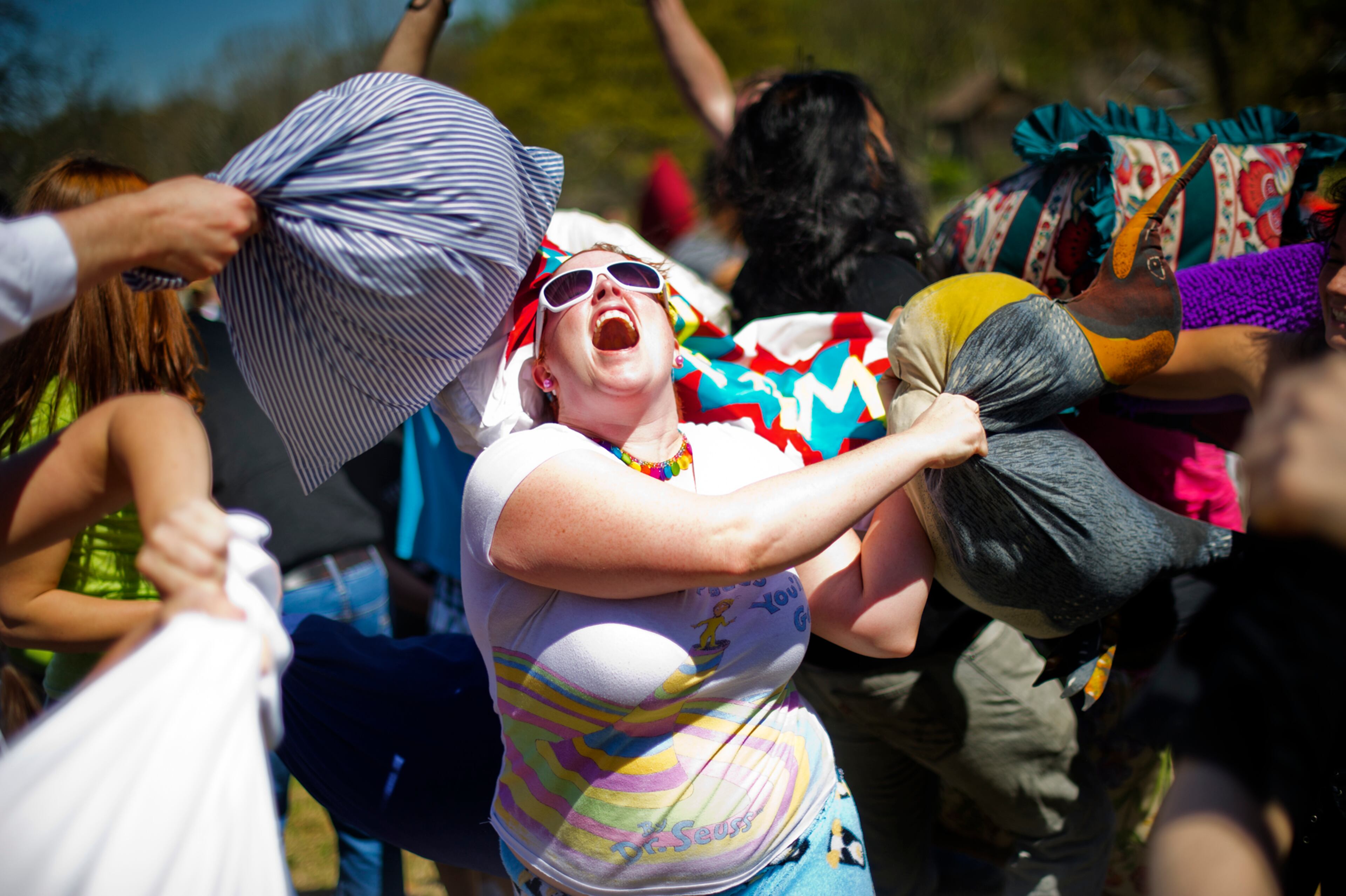 Christine Penguino (center) swings her penguin pillow wildly during the pillow fight at Freedom Park in Little Five Points on April 6, 2013. For the fifth year in a row, hundreds of residents from Atlanta and the surrounding communities participated in International Pillow Fight Day.