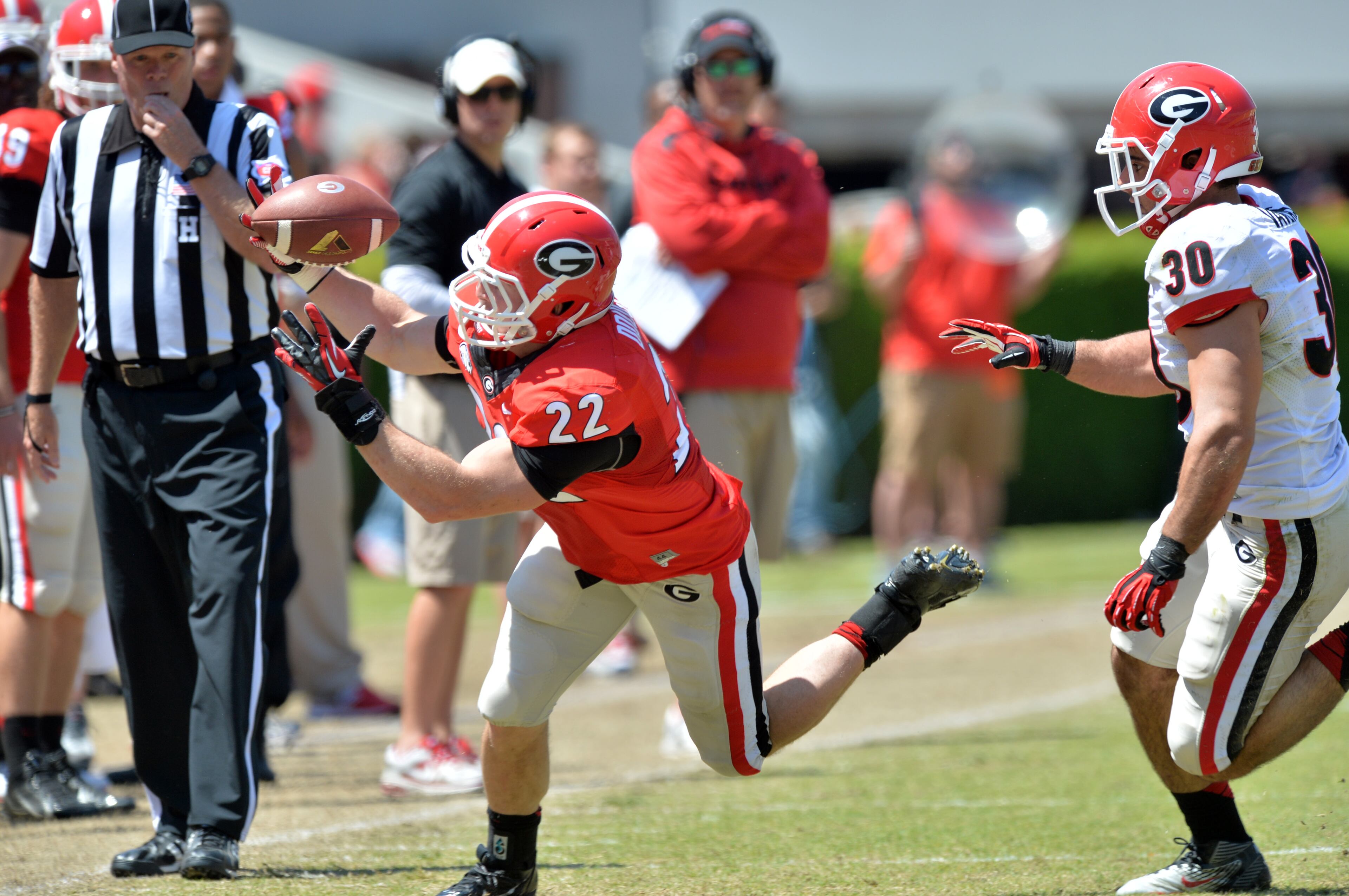 Bulldogs running back Brendan Douglas (22) chases a loose ball as Georgia Bulldogs linebacker Kosta Vavlas (30) follows.