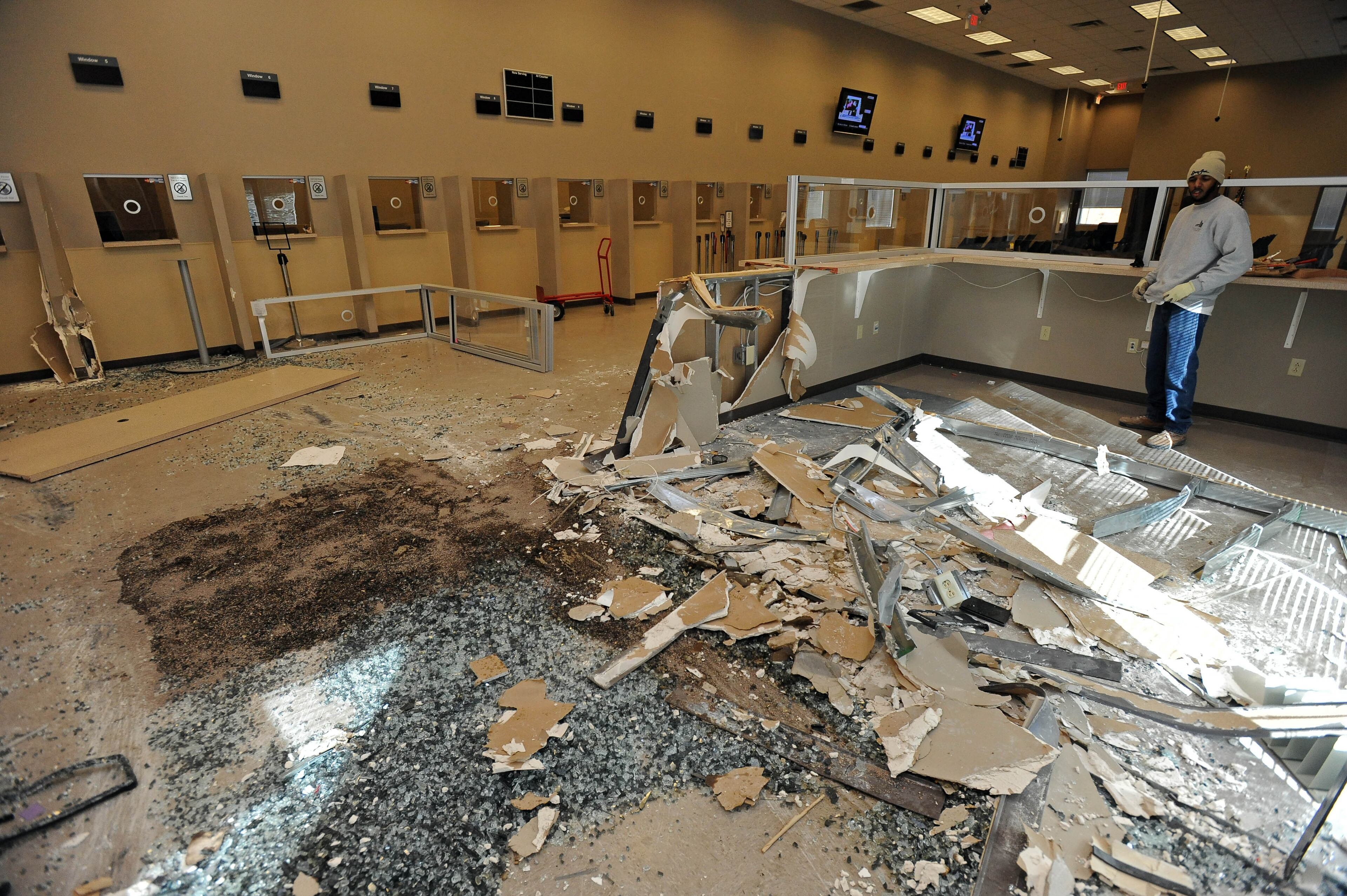Debris litters the floor at the Department of Motor Vehicle Division's East Point, Ga., facility after criminals allegedly drove a van into the structure to steal two ATM machines on Thursday, Dec. 26, 2013. Investigator Josh Waites of the Department of Revenue said the office is the only metro location offering replacement car titles and suggested customers call 855-406-5221 or visit www.etax.dor.ga.gov before making a trip to the facility.