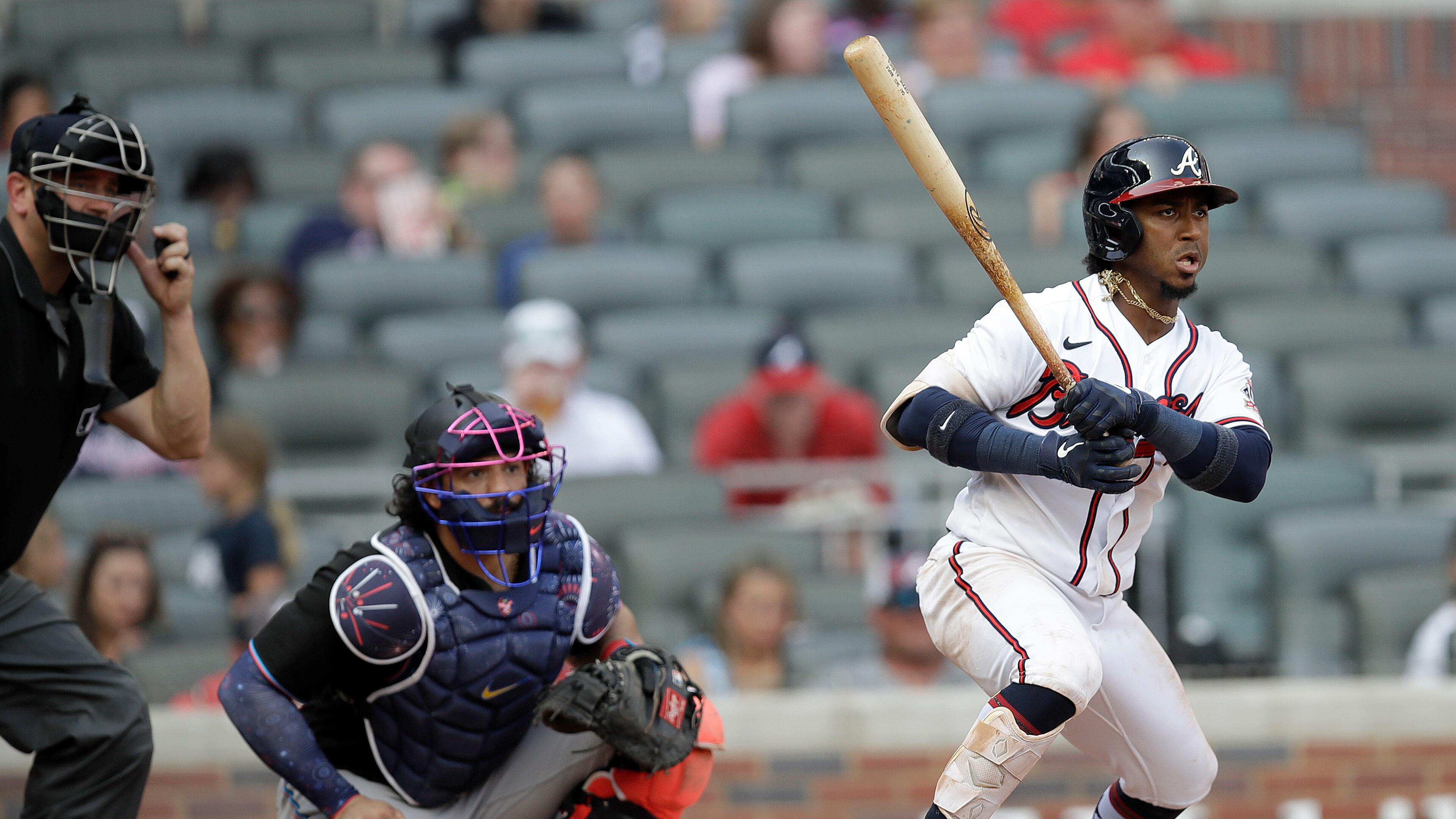 Atlanta Braves' Ozzie Albies, right, watches his RBI-single against the Miami Marlins during the fifth inning of a baseball game Saturday, July 3, 2021, in Atlanta. (AP Photo/Ben Margot)