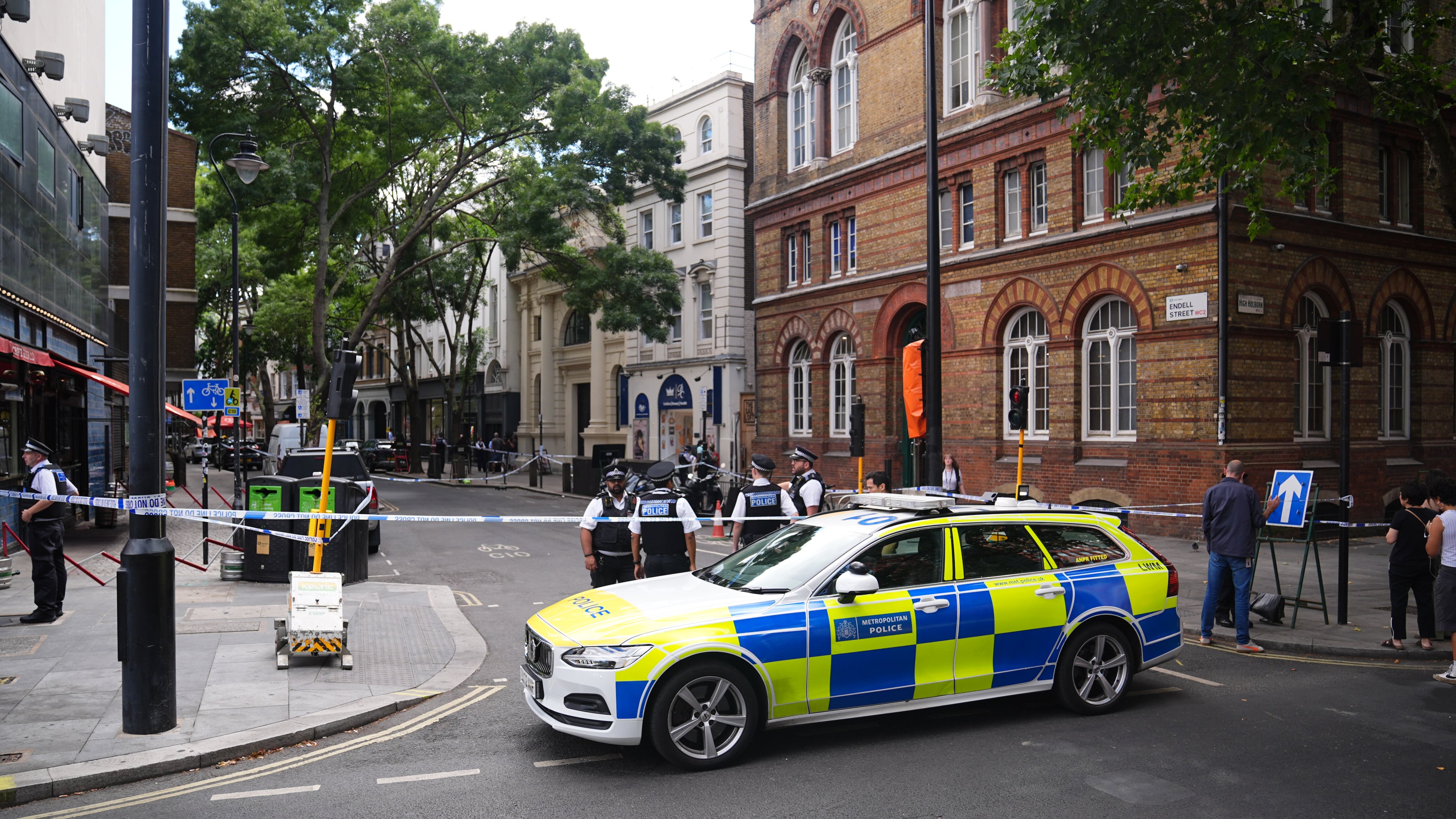 Police officers stand at the scene on Endell Street in Covent Garden, after four men were stabbed, in central London, Wednesday Aug. 5, 2026. PA Photo. (James Manning/PA via AP)