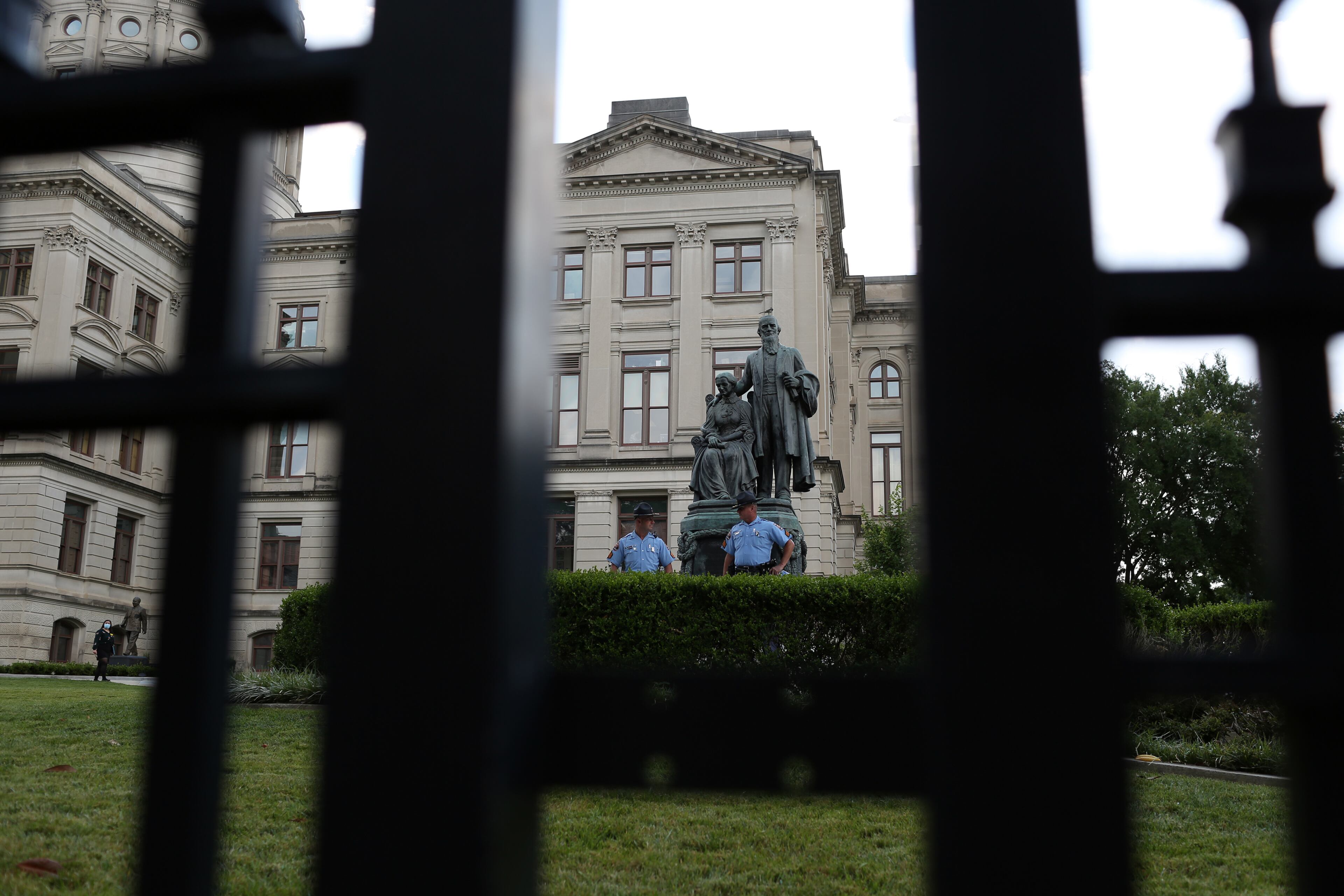 Georgia state troopers stand near a statue as protesters march from the Richard B. Russell Federal Building to the Georgia State Capitol in downtown Atlanta for March on Georgia, a protest hosted by the Georgia chapter for the NAACP, on Monday, June 15, 2020. (REBECCA WRIGHT FOR THE ATLANTA JOURNAL-CONSTITUTION)