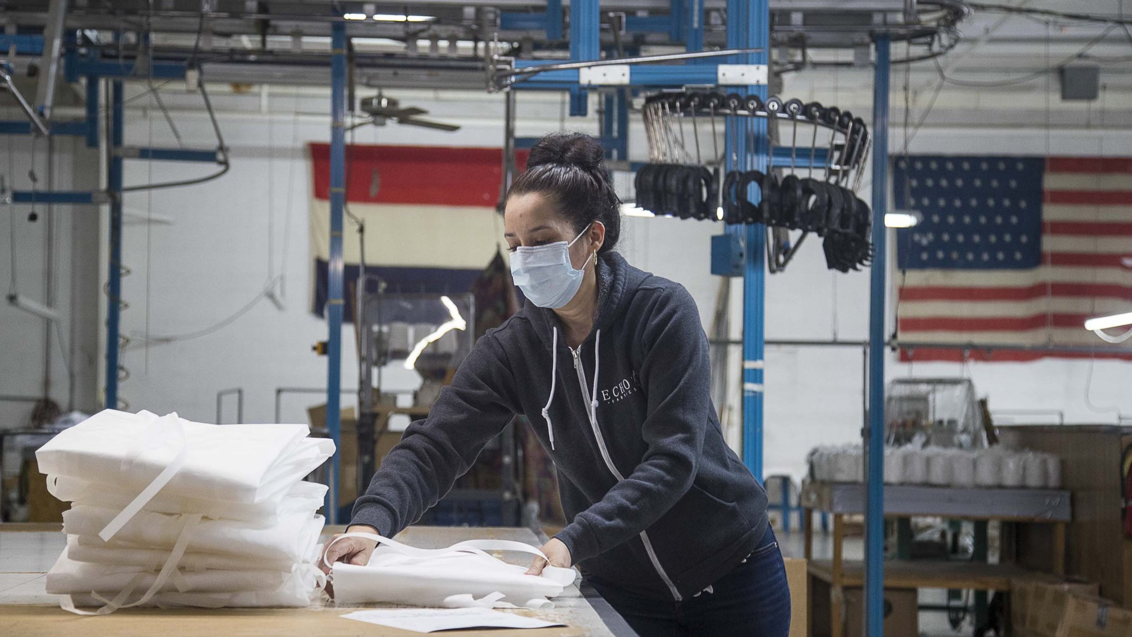 Sidia Ventura folds isolation medial gowns as she prepares to box them at Echota Fabrics, Inc. in Calhoun on April 8, 2020. Echota normally produces fabrics for curtains and bedding, but is participating in an informal regional consortium making medical gowns and fabric face masks for health-care workers responding to the COVID19 pandemic. (ALYSSA POINTER / ALYSSA.POINTER@AJC.COM)
