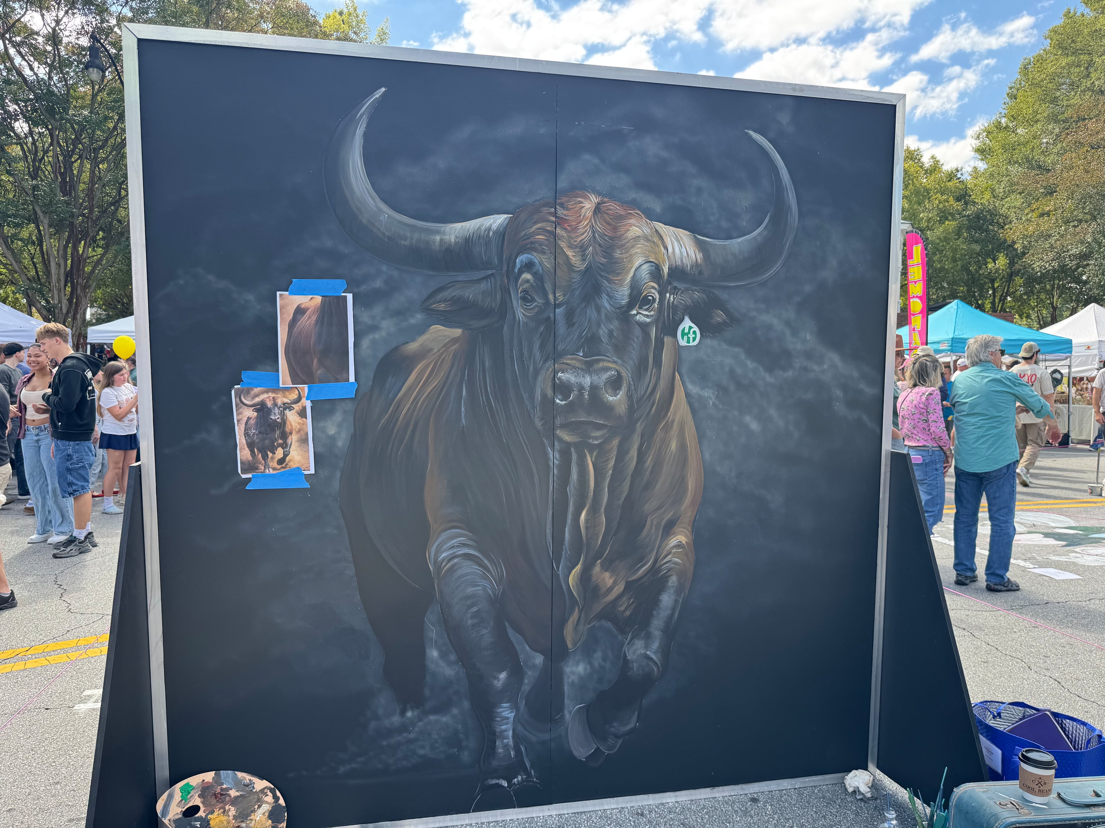 Douglas' Lee Mobley has yet to finish this latex paint mural of a bull at Chalktoberfest in Marietta on Saturday, Oct. 11, 2025. (Caleb Groves/ AJC)