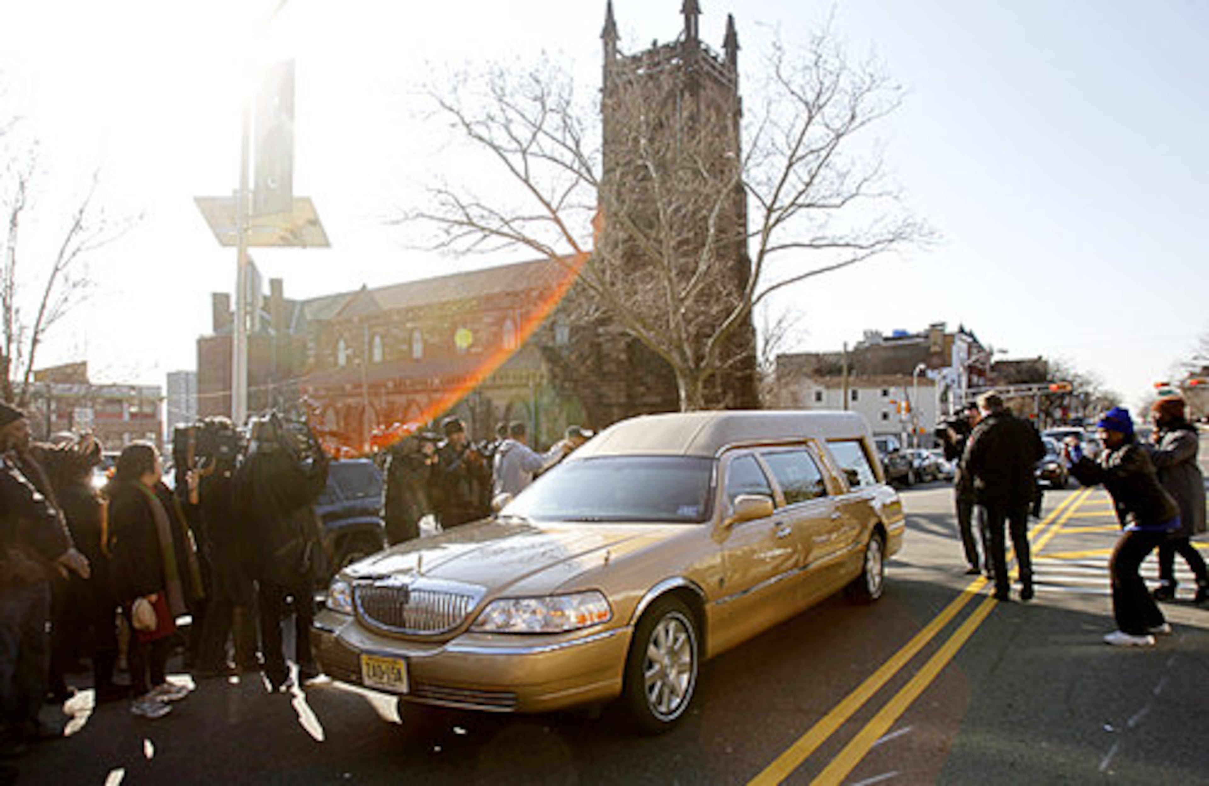 Fans and the media snap photos as the hearse carrying the body of Whitney Houston leaves Whigham Funeral Home in Newark, N.J.on Saturday, Feb. 18, 2012.