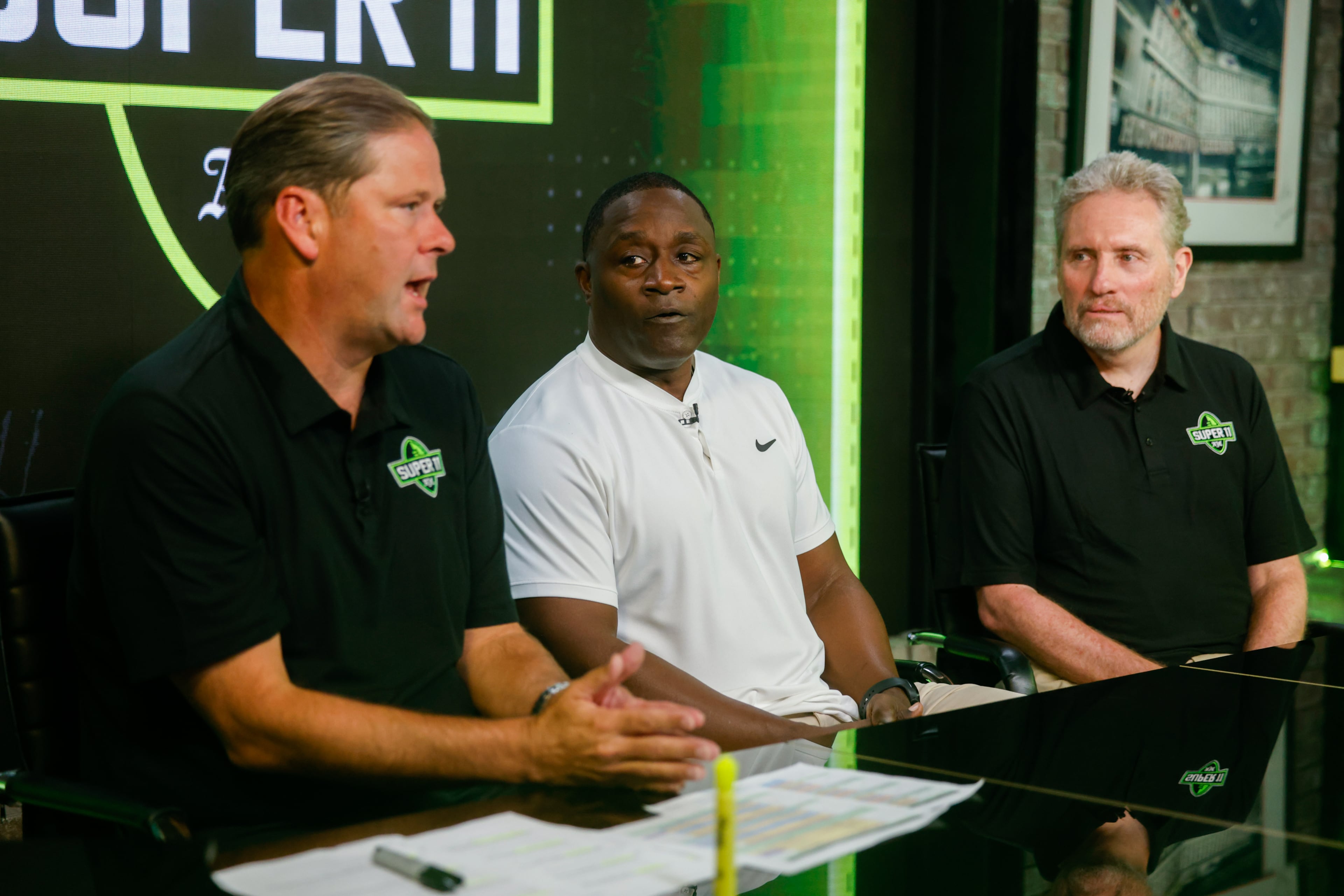 DawgNation’s Brandon Adams appears with former Super 11 honoree Garrison Hearst and AJC’s Todd Holcomb during the taping of the Super 11 reveal show at Score ATL in Roswell on Aug. 3, 2026. (Arvin Temkar/AJC)