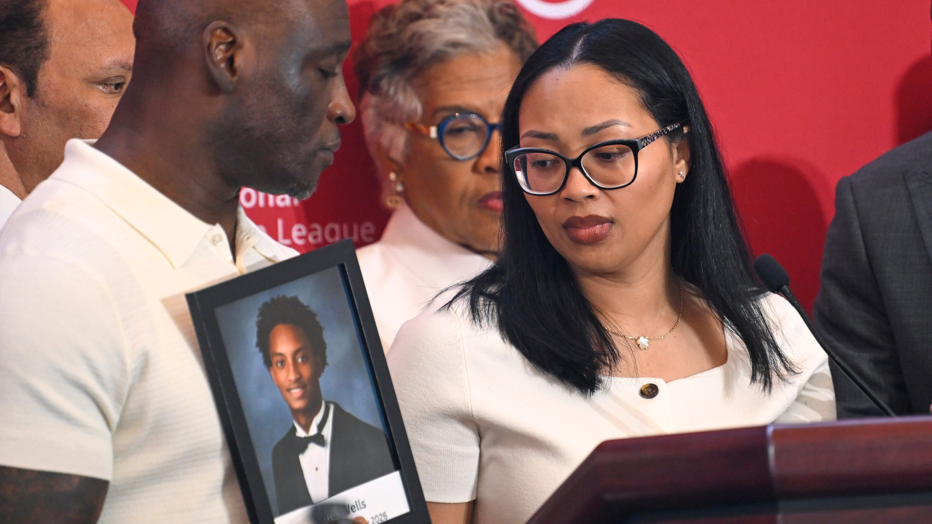 Christine Wonsley looks at a photo of her deceased son, Nolan Wells, as husband Elmore Wonsley, left, stands at her side as they appear at the National Urban League's annual conference, Thursday, July 30, 2026, in Nashville, Tenn. (John Amis/AP)