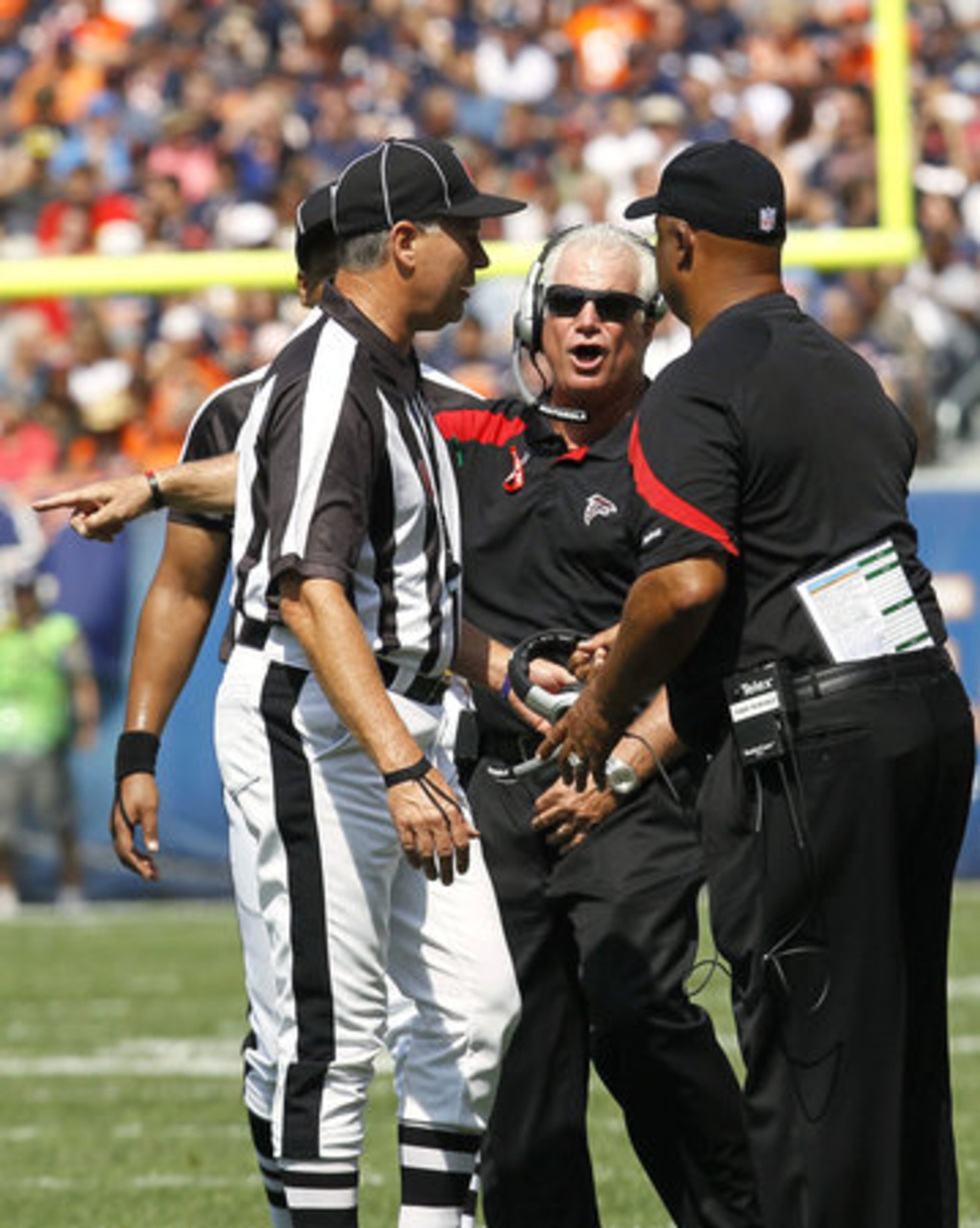 Atlanta Falcons head coach Mike Smith, center, talks with referees after a play against the Chicago Bears in the first half.