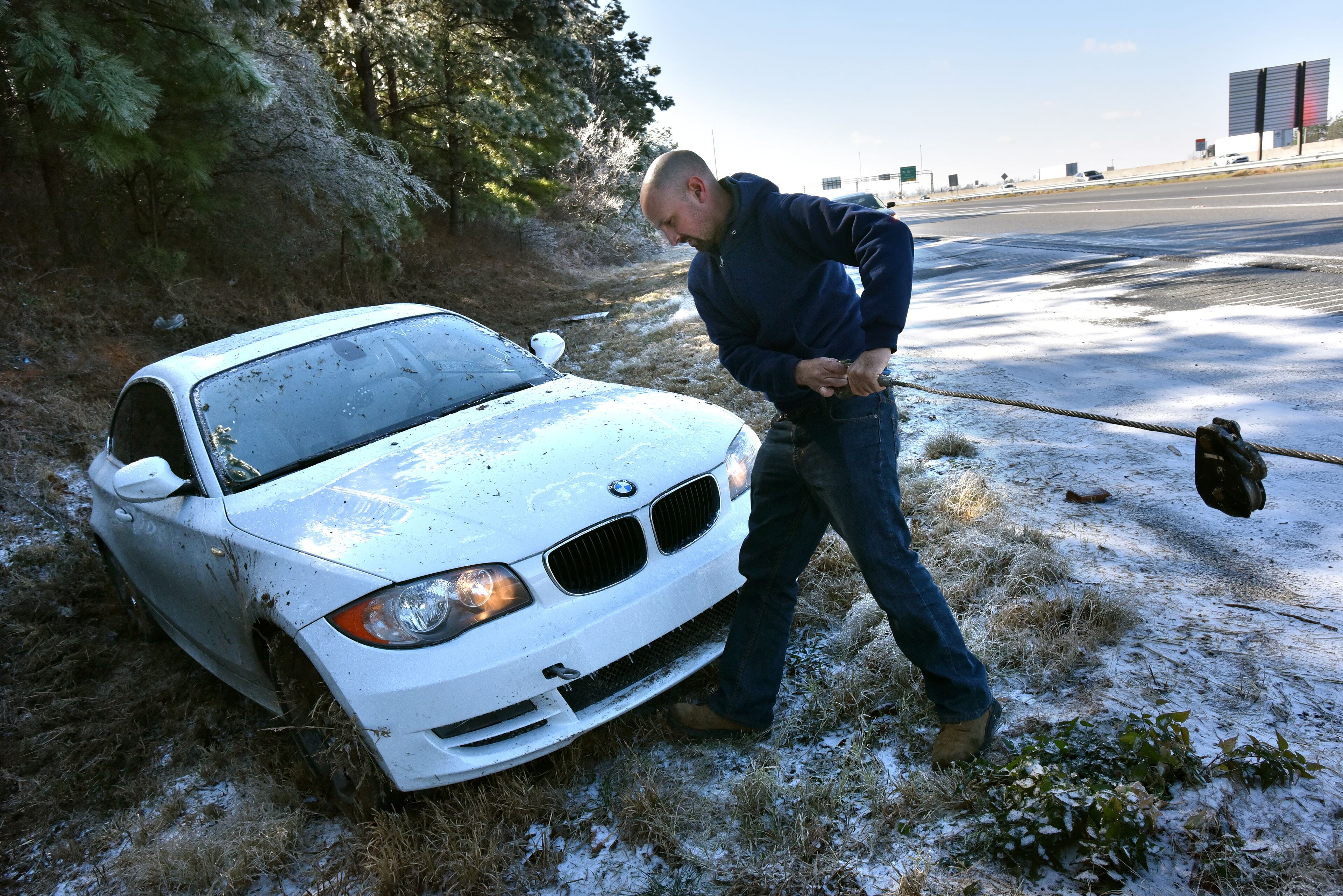 January 7, 2017 Lawrenceville - Gabriel Suarez with J & S Towing Service prepares the vehicle for towing from a difficult position alongside I-85 northbound near Old Peachtree Road exit in Gwinnett County on Saturday, January 7, 2017. Snow fell in parts of Georgia on Friday night, but much of metro Atlanta got very little or no snow at all. Still, many areas Saturday are facing icy conditions on the roads. There is a danger of slick conditions on bridges and overpasses, Channel 2 Action News meteorologist Karen Minton said. HYOSUB SHIN / HSHIN@AJC.COM