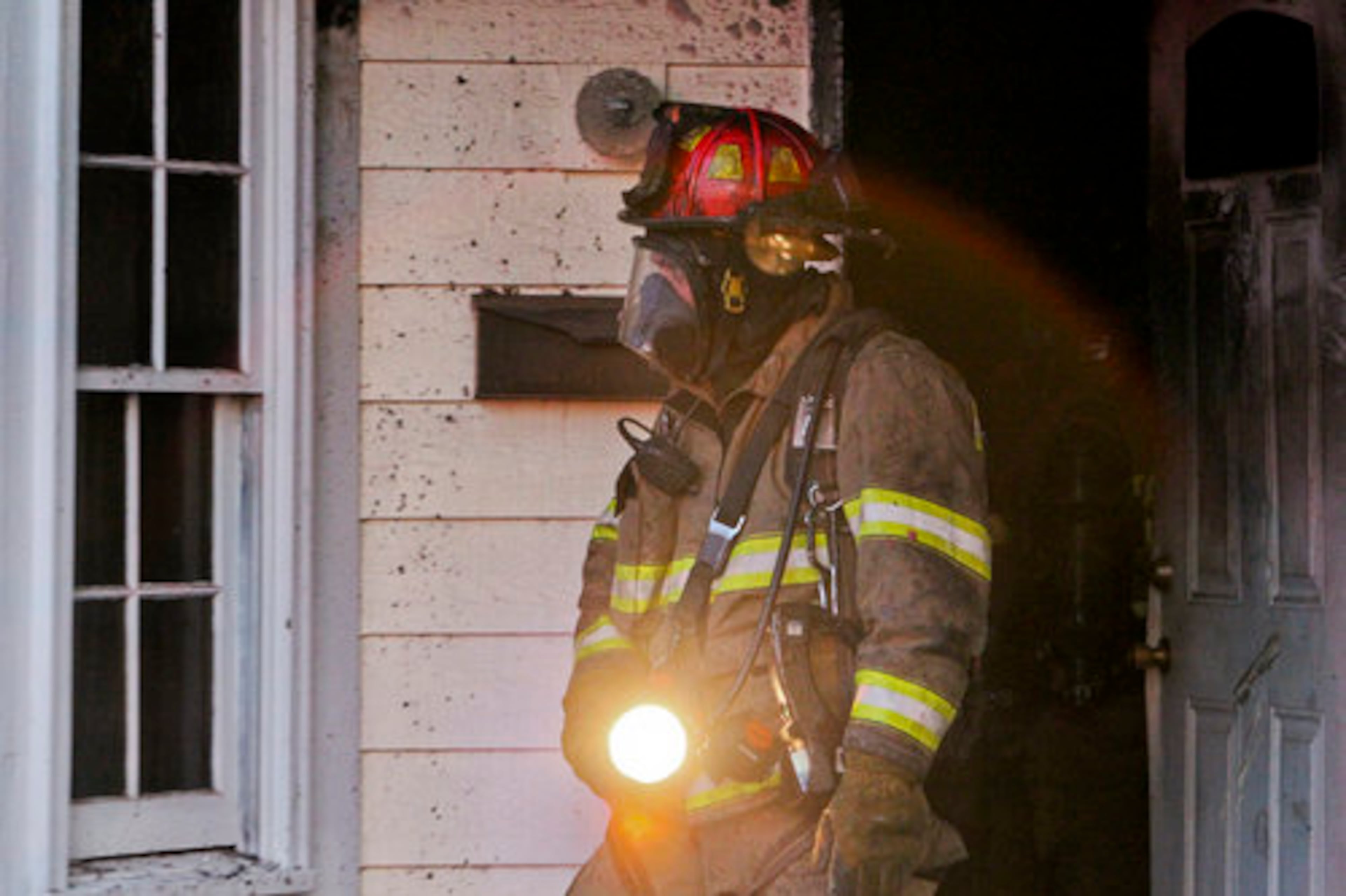 A firefighter returns from his interior search of the house of Jonesboro Road in the Lakewood Heights area of southeast Atlanta after a man was rescued.