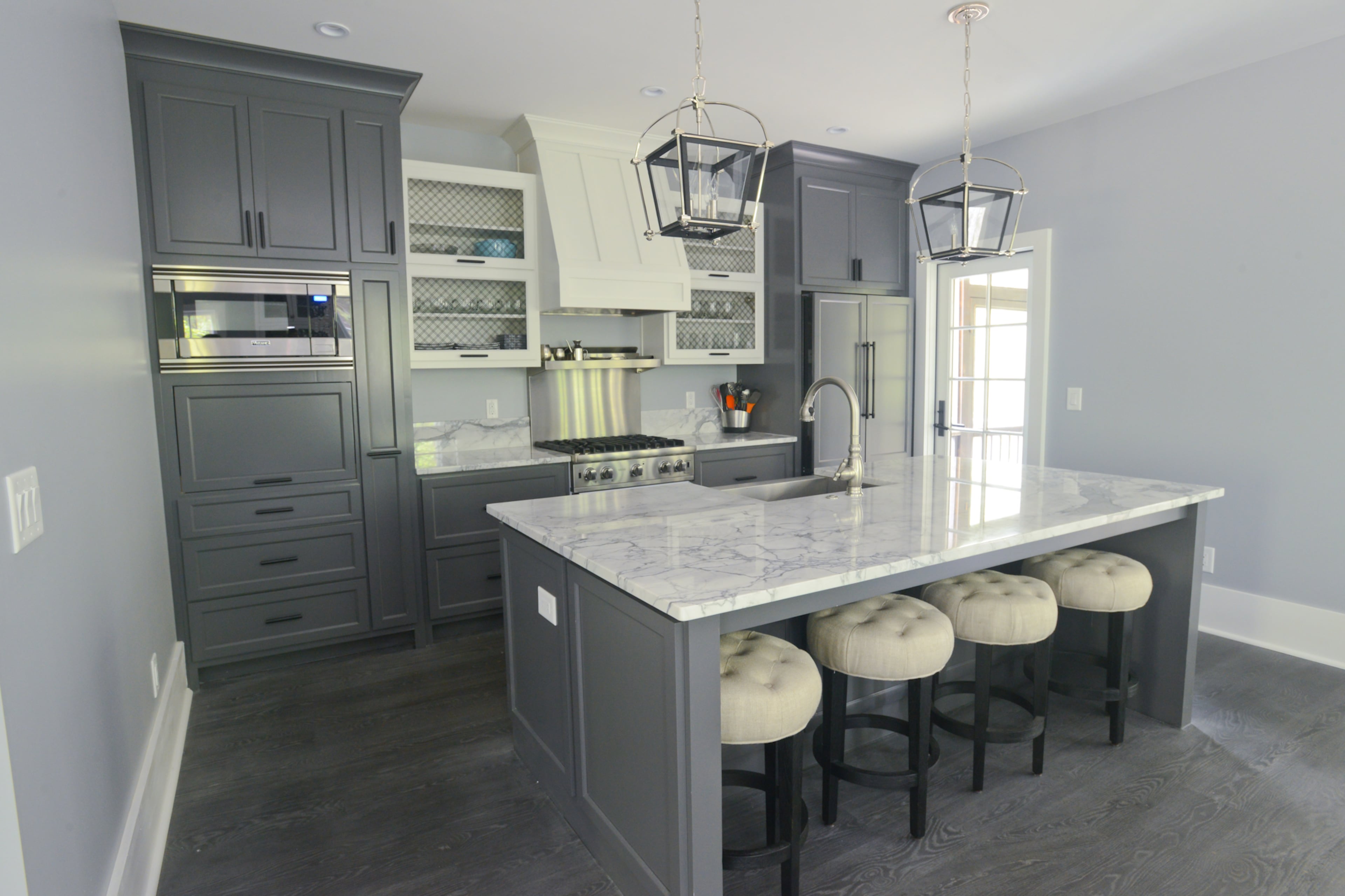 The small kitchen in the English-style cottage opens to the rest of the first floor, so the couple worked to maximize the use of the space by building in an appliance garage to keep things off the countertops and adding a pull-out spice rack that also doubles as a small pantry.