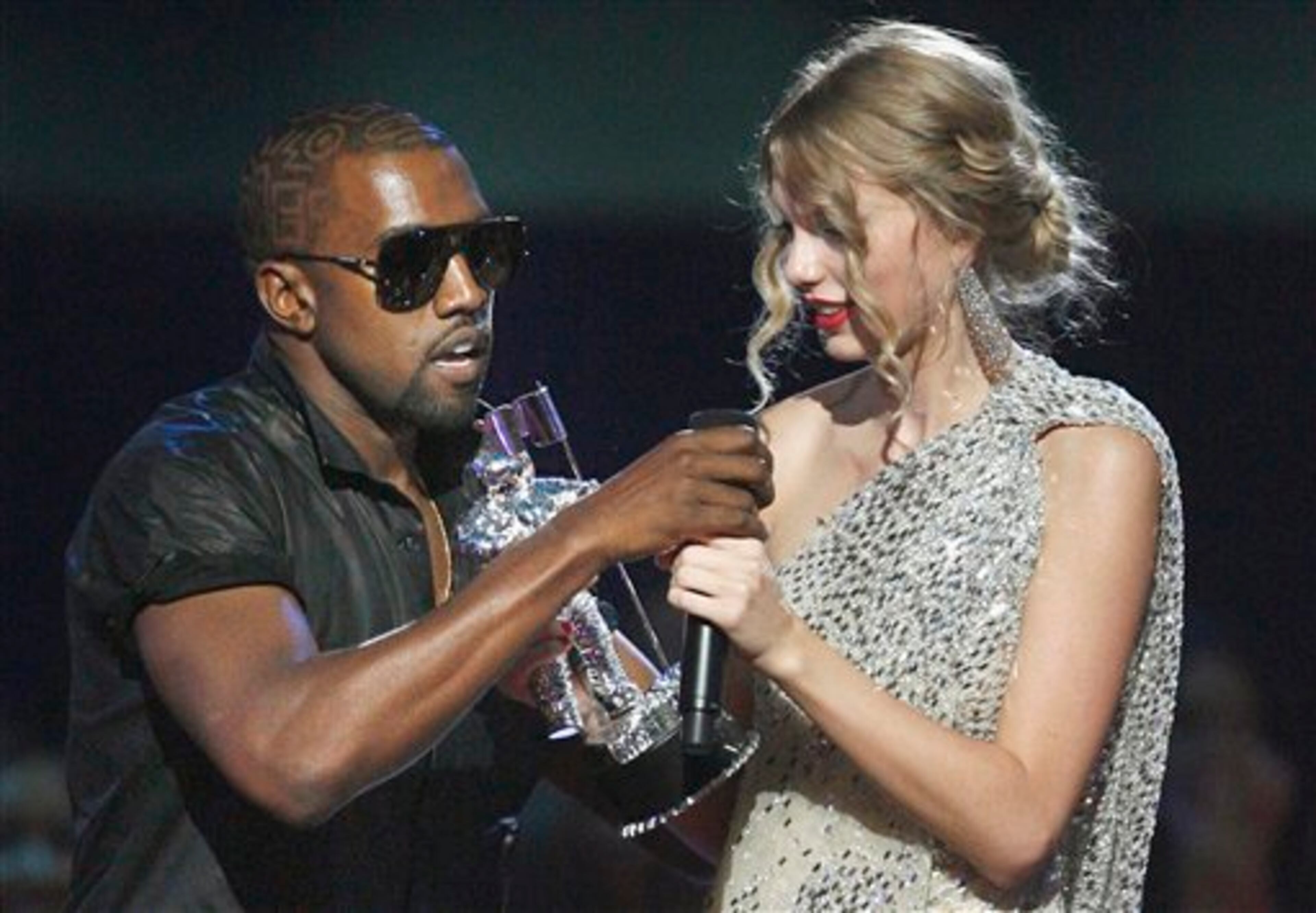 Kanye West takes the microphone from Taylor Swift as she accepts the "Best Female Video" award during the MTV Video Music Awards in New York on Sept 13, 2009. (AP Photo/Jason DeCrow, File)