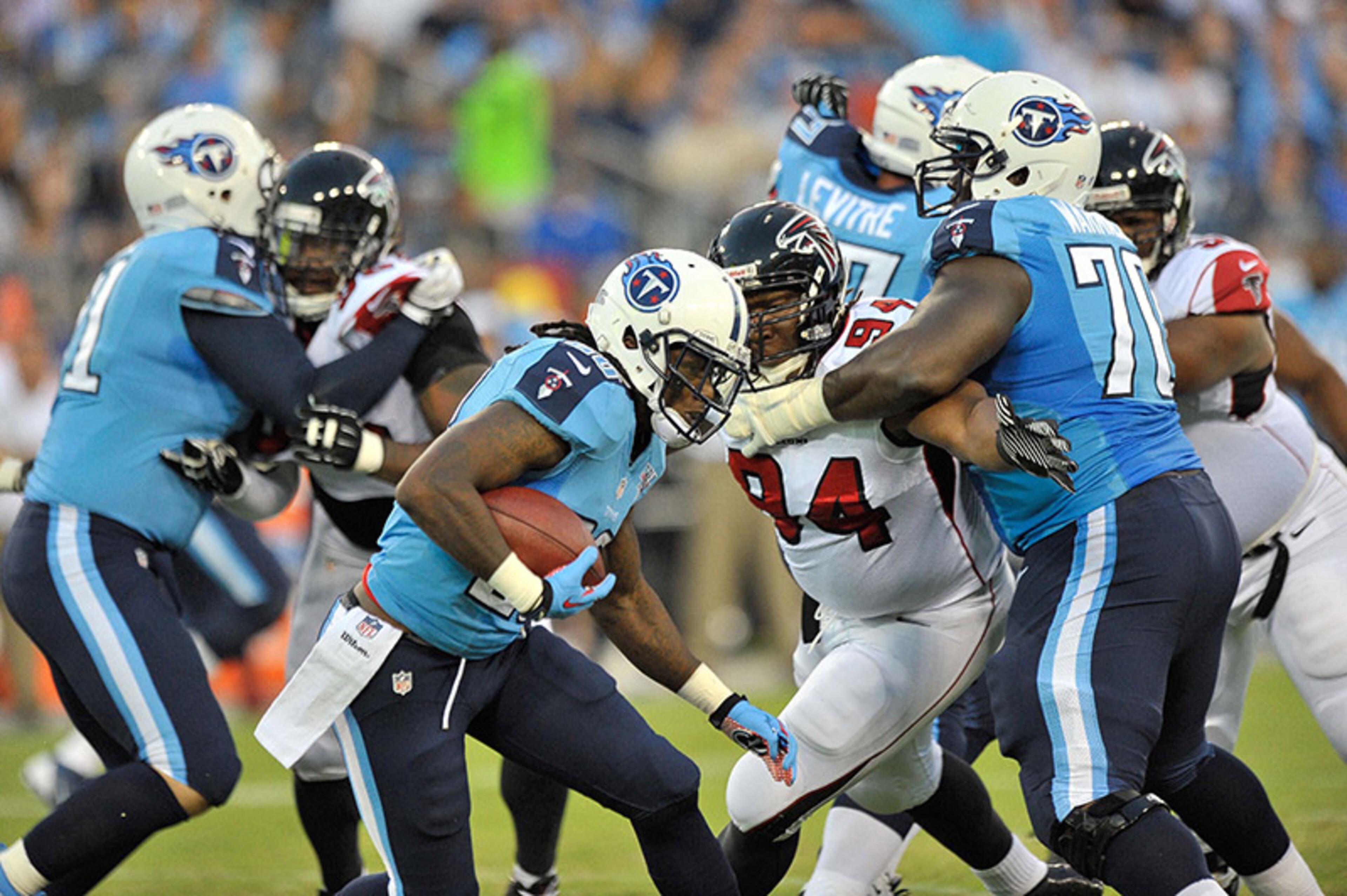 Titans running back Chris Johnson (28) rushes past the Falcons defensive line.