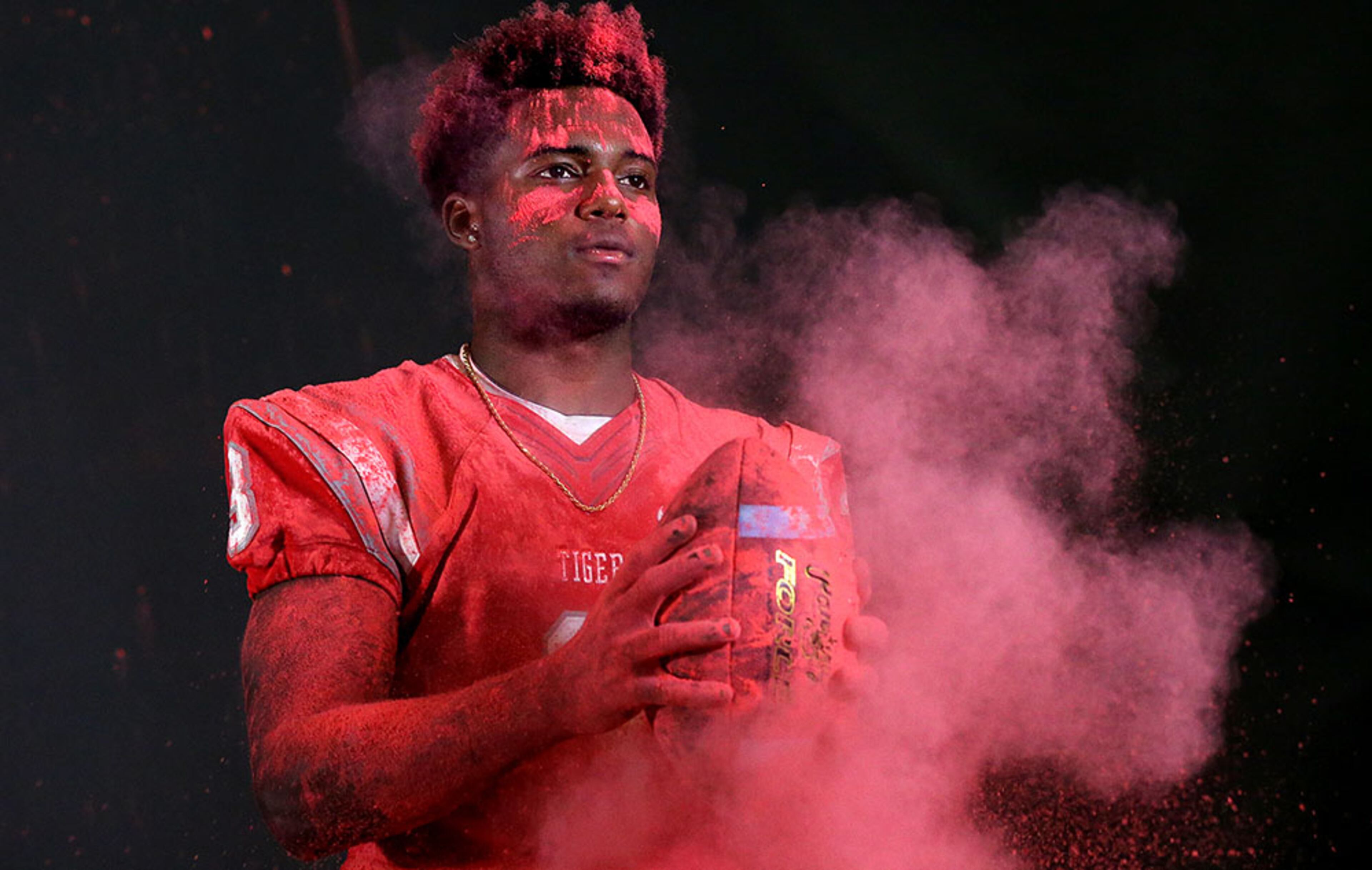 Archer High School defensive back Dylan Singleton lets the dust fly as he pounds the football for his AJC Super 11 portrait. A key light was used from the side to light the faces of the football players and a main light was used to fill the subject enough from the front side to prevent getting a silhouette.