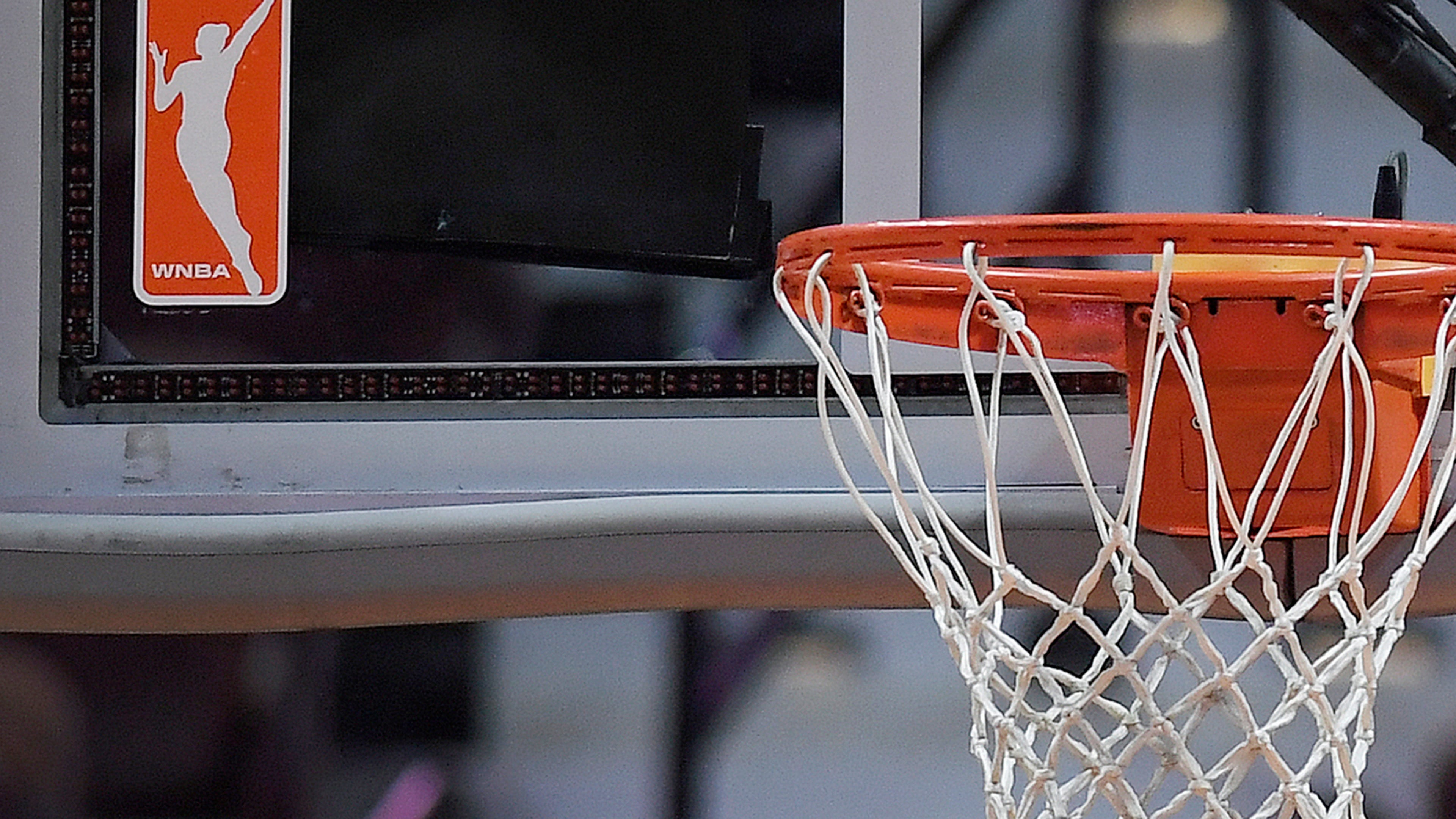 FILE - The WNBA logo is seen near a hoop before an WNBA basketball game at Mohegan Sun Arena, May 14, 2019, in Uncasville, Conn. (AP Photo/Jessica Hill, File)