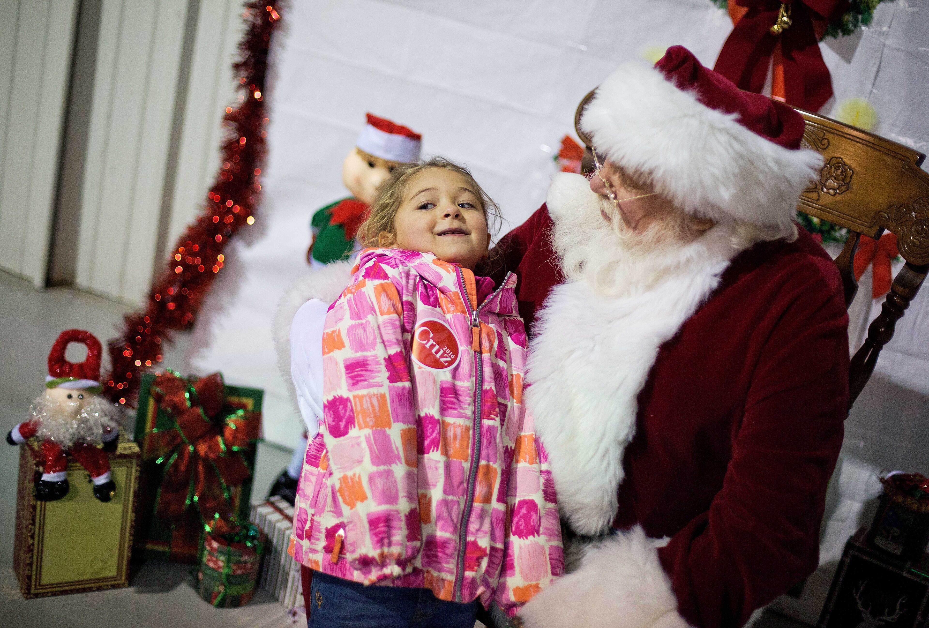 Annabelle Schaeffer, 5, left, sits on Santa Claus' lap before Republican presidential candidate, Sen. Ted Cruz, R-Texas, arrives for a campaign event Friday, Dec. 18, 2015, in Kennesaw, Ga. Cruz is on an eight-state, 12-city "Christmas Tour," and at each stop, the campaign plans to have Santa Claus on hand, posing for pictures and kissing babies. (AP Photo/David Goldman)