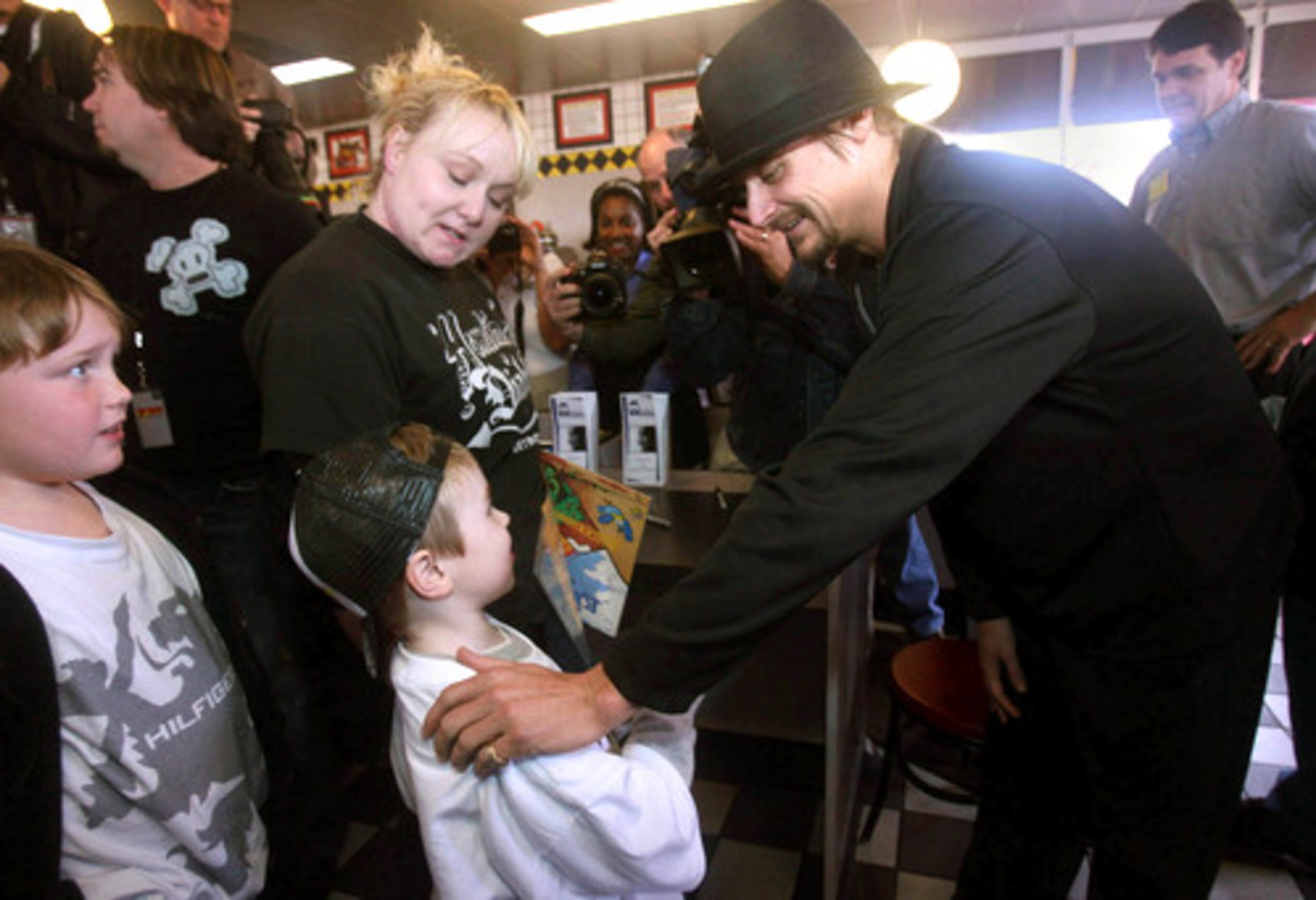 Kid Rock talks with 7-year-old Carson Taylor as his mom Alisha Mullen and her 10-year-old brother Brady Taylor listen in.