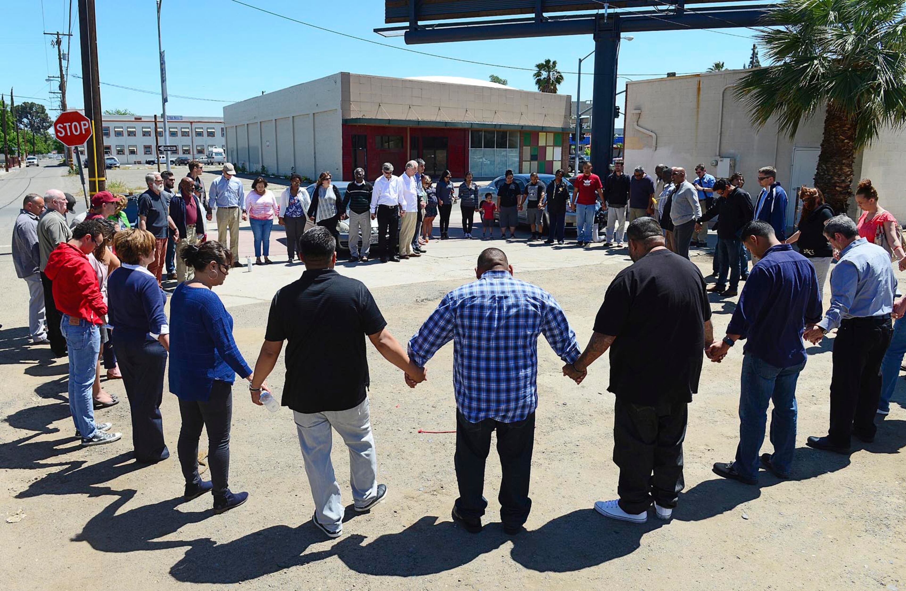 Pastors and church leaders gather for a final prayer following a payer walk for the victims of last Tuesday's triple-homicide near downtown Fresno, Calif., Thursday, April 20, 2017. Members of the Pastor Clusters of the Fresno/Clovis area traced the route of the alleged killer, holding prayers at the location of each victim. (Craig Kohlruss /The Fresno Bee via AP)