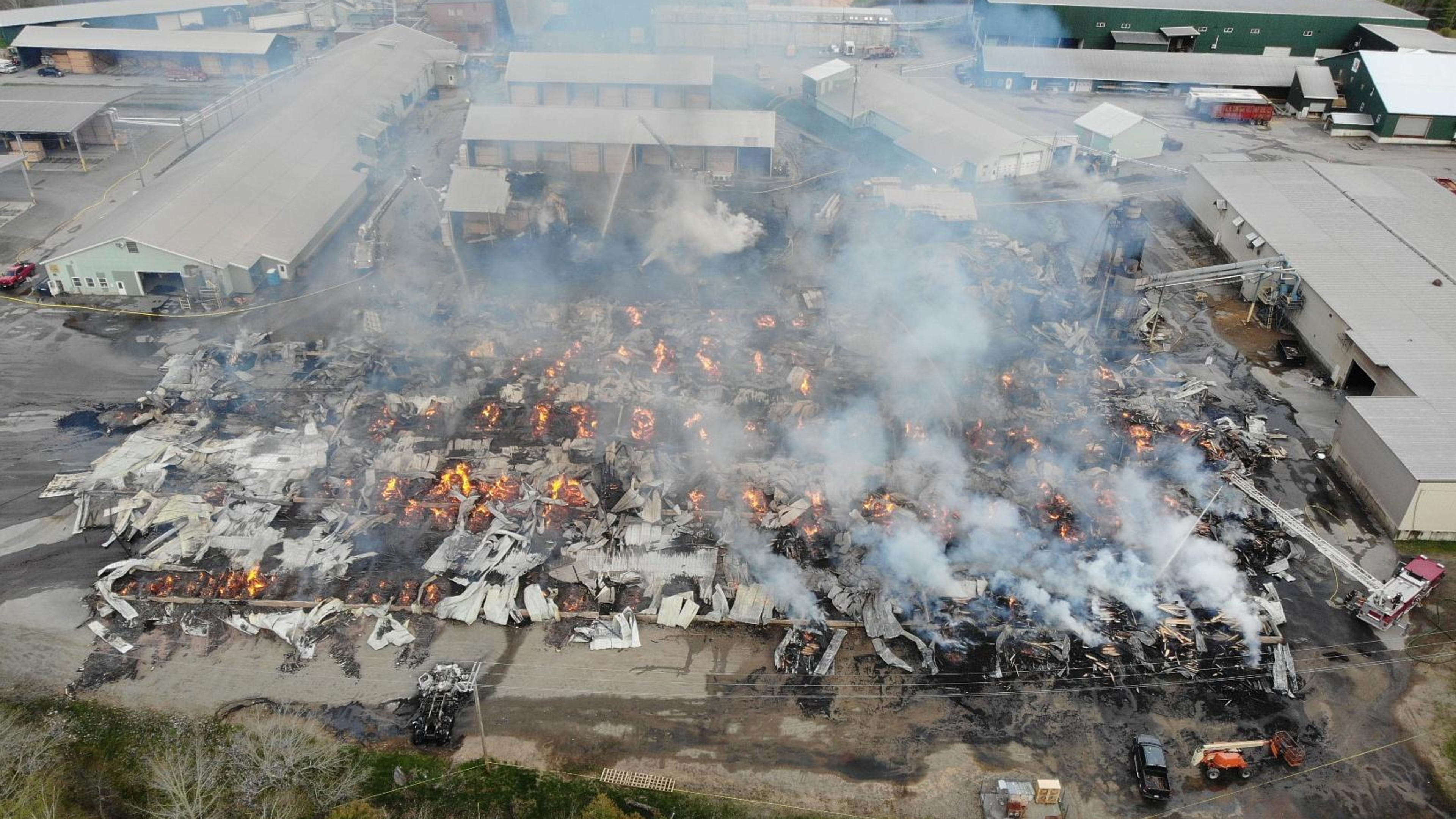 In this photo provided by the Maine State Fire Marshal, flames burn through Robbins Lumber following an explosion, May 15, 2026, in Searsmont, Maine. (Maine State Fire Marshal via AP)