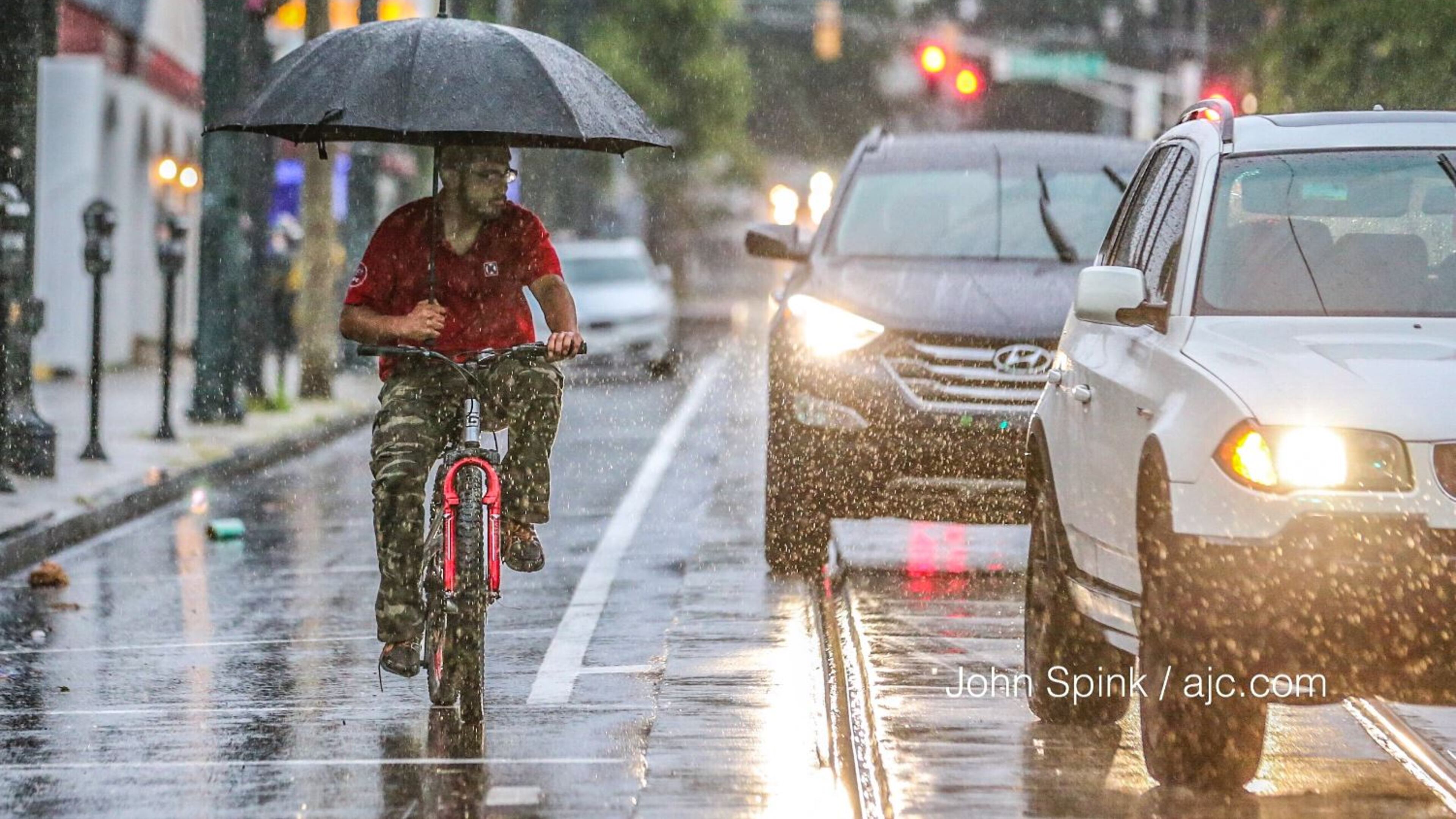 Ravi Sing tried to stay dry Tuesday morning as he waited for the light to change on Auburn Avenue and Hilliard Street in downtown Atlanta. JOHN SPINK / JSPINK@AJC.COM