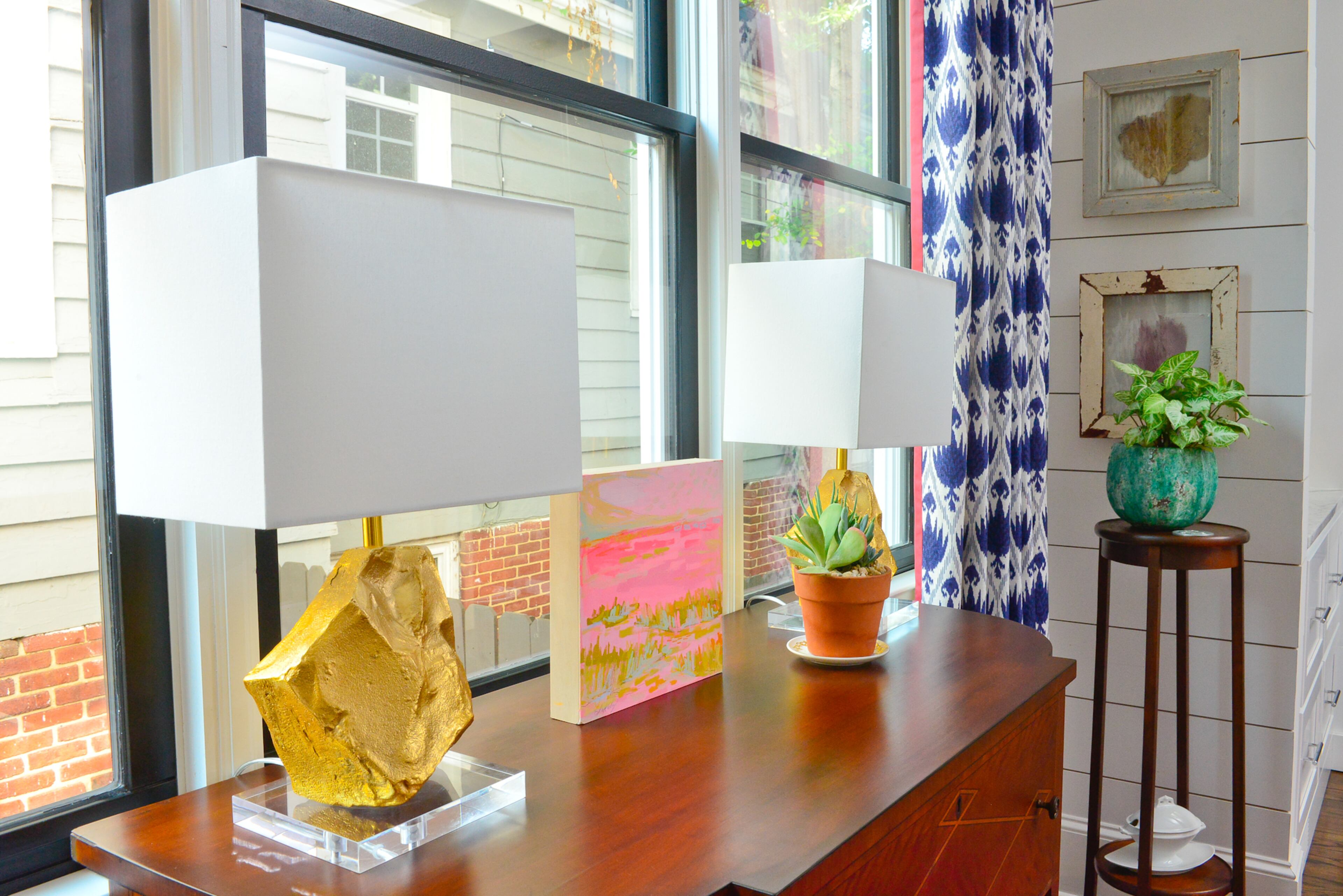 These Lyndon Leigh lamps add a glam rustic touch to the space. White said that when she moved in, the home had a lot of grays and silvers, and she enjoyed incorporating gold into the mix. Shades of pink in the artwork by Blakely Little of Charleston, South Carolina, add another layer of color.