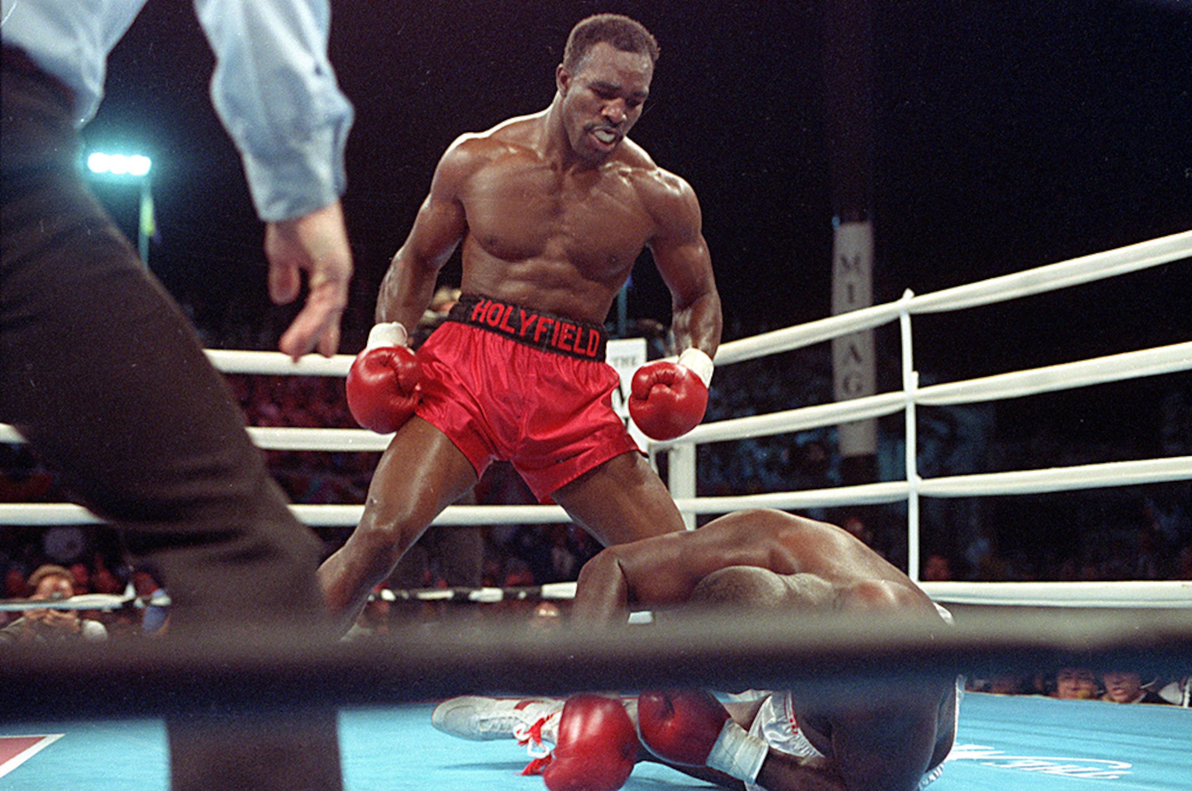 Evander Holyfield stands above the knocked-out James "Buster" Douglas in the third round of their heavyweight title bout, on Oct. 25, 1990, at the Mirage Hotel in Las Vegas.