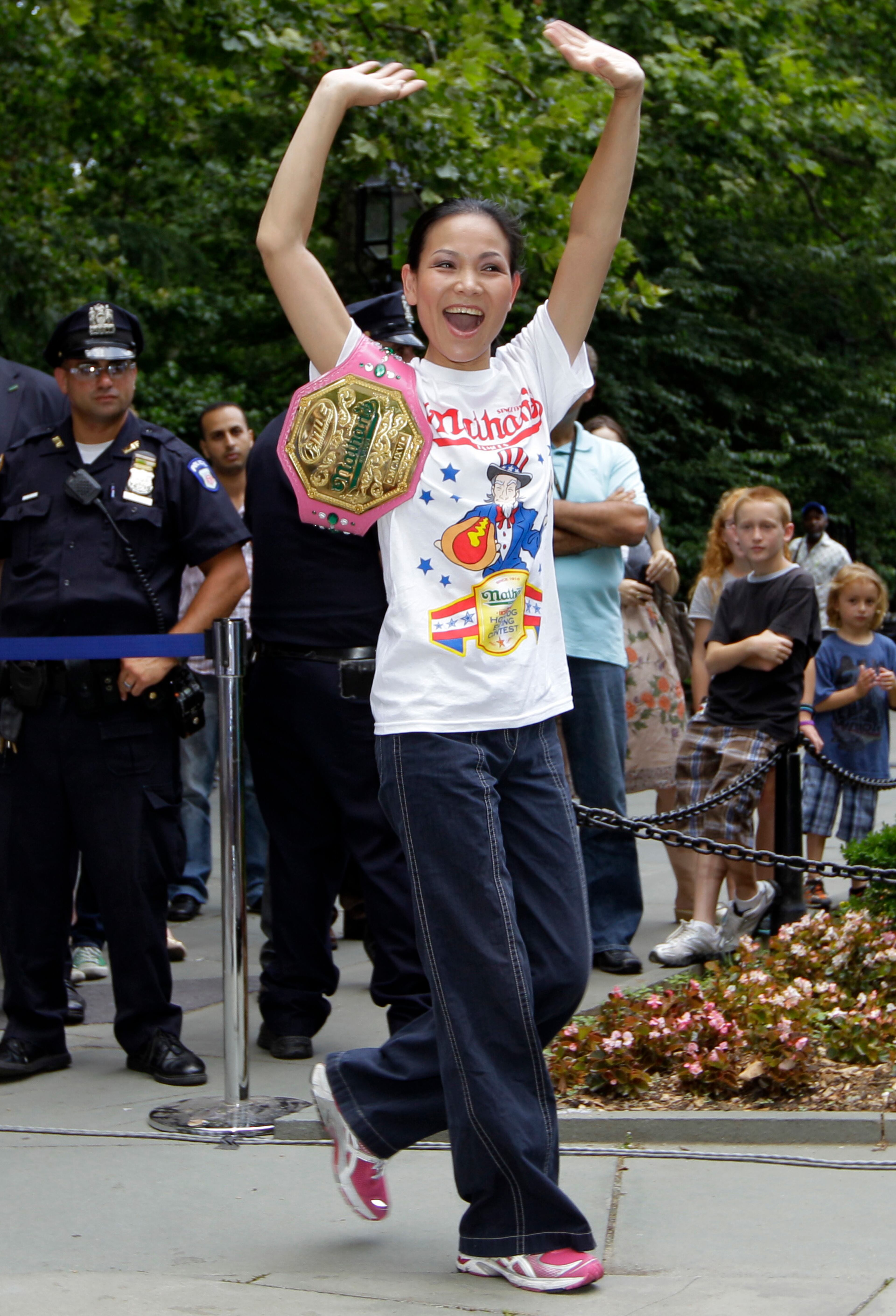 Spectators watch as Sonya "The Black Widow" Thomas is introduced during a weigh-in for contestants in the annual Coney Island Fourth of July international hot dog-eating contest at City Hall park in New York, Tuesday, July 3, 2012. Thomas , who weighs 100 pounds, holds more than 30 world hot dog-eating records, (AP Photo/Kathy Willens)
