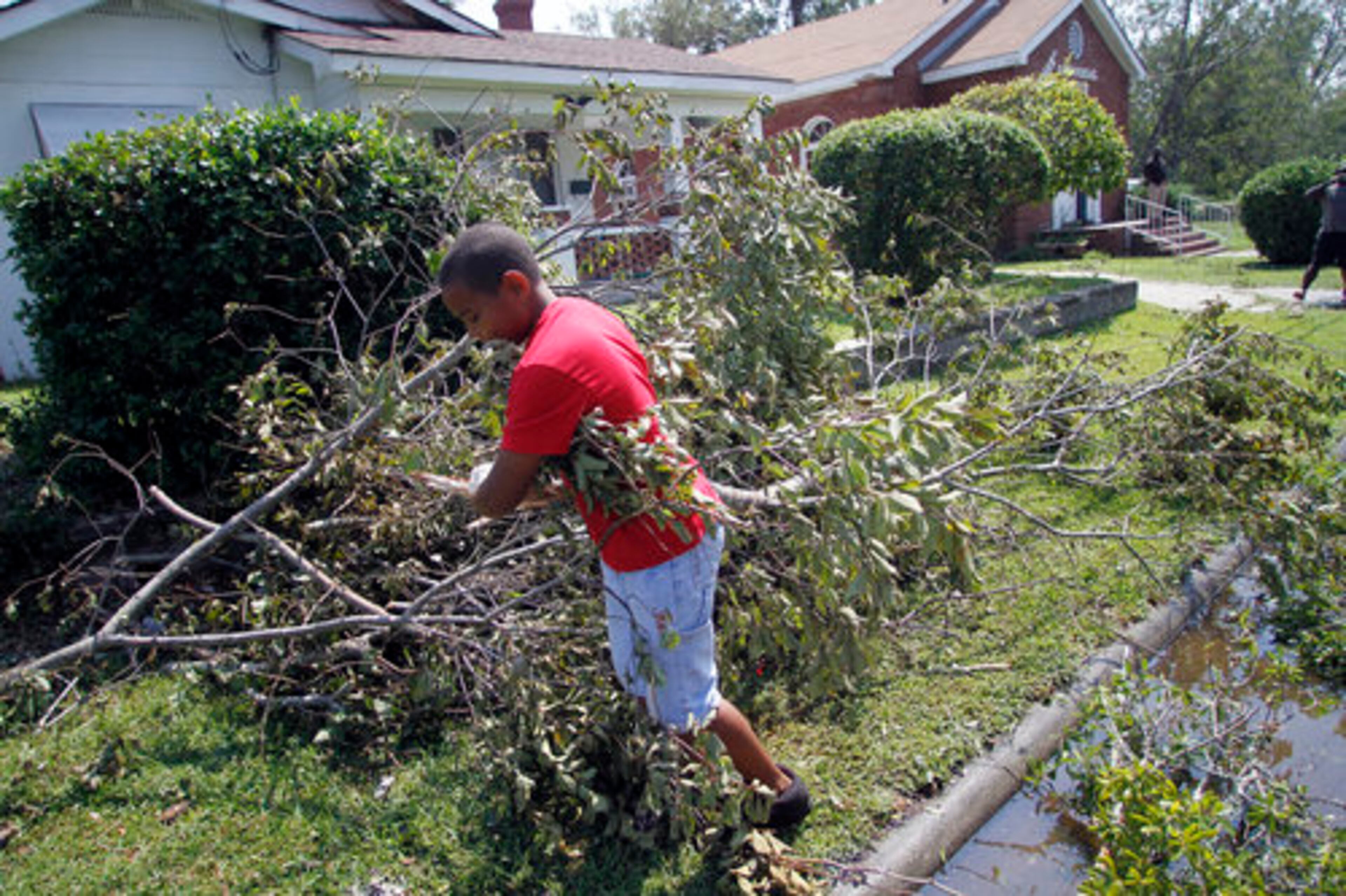 tephan Misa moves tree limbs from the front of his home during the aftermath of Hurricane Irene, Sunday, Aug. 28, 2011 in New Bern, N.C.