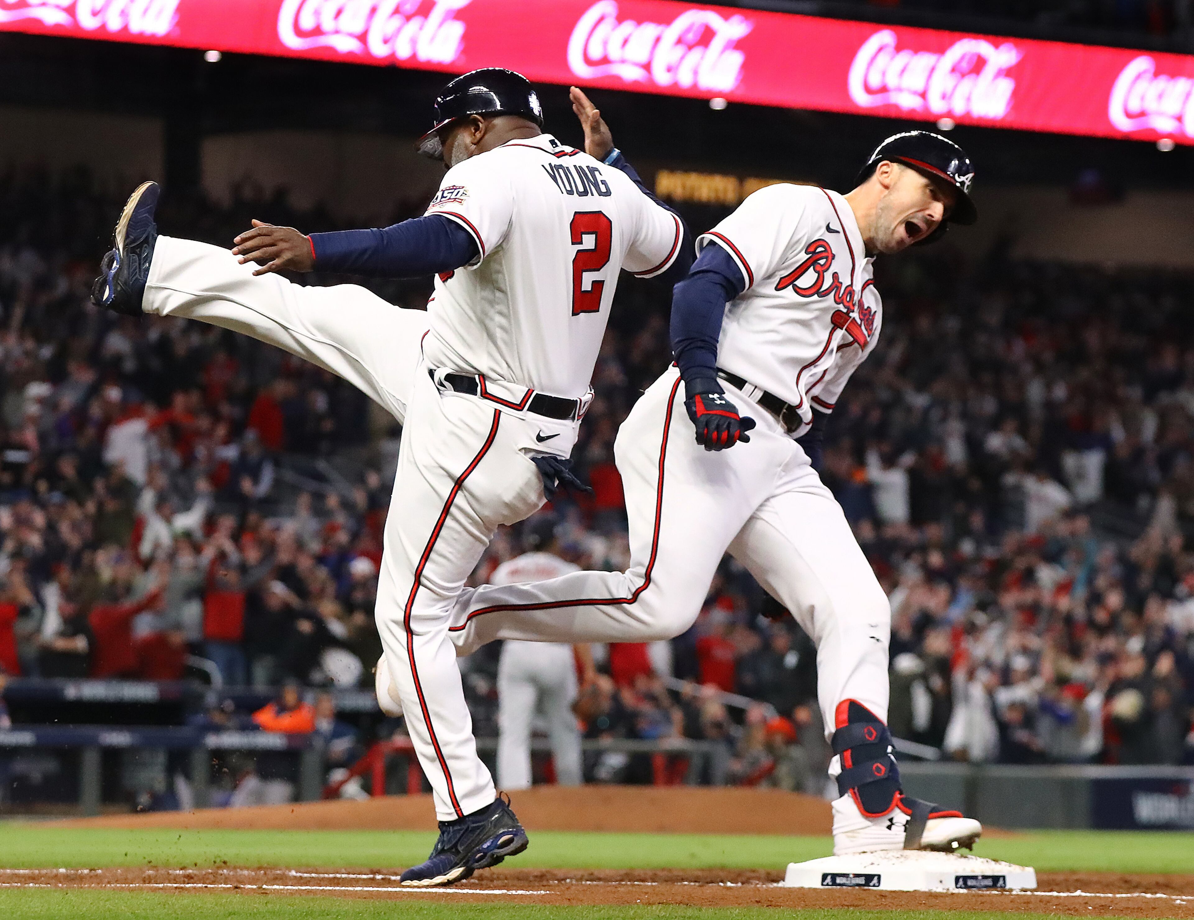 103121 ATLANTA: --GRAND SLAM -- Braves first base coach Eric Young kicks his leg in jubilation as Adam Duvall rounds first base hitting a grand slam against the Astros during the first inning in game 5 of the World Series on Sunday, Oct. 31, 2021, in Atlanta. “Curtis Compton / Curtis.Compton@ajc.com”