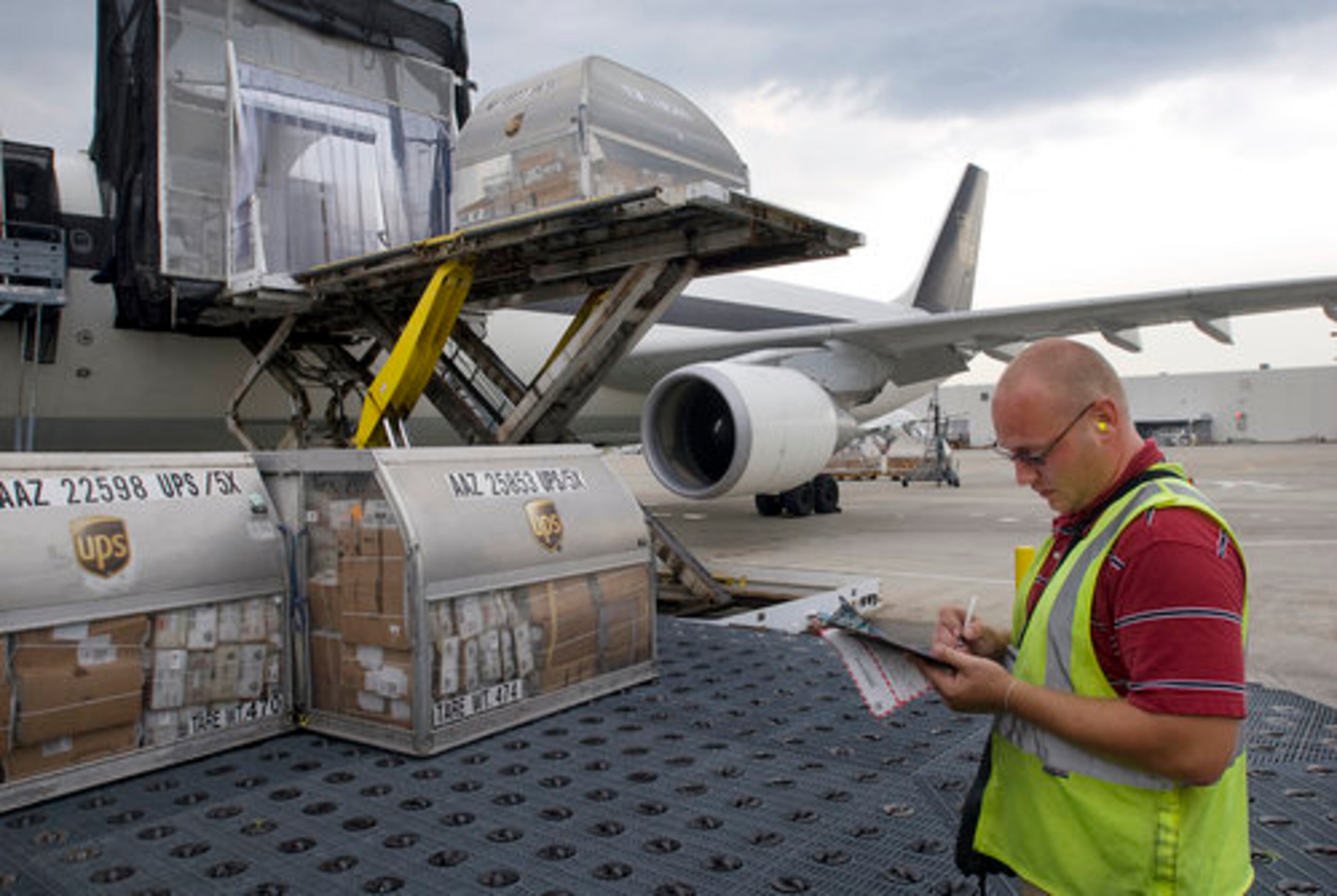 Tony Biller, a UPS front-line supervisor, checks arriving containers against his documents.