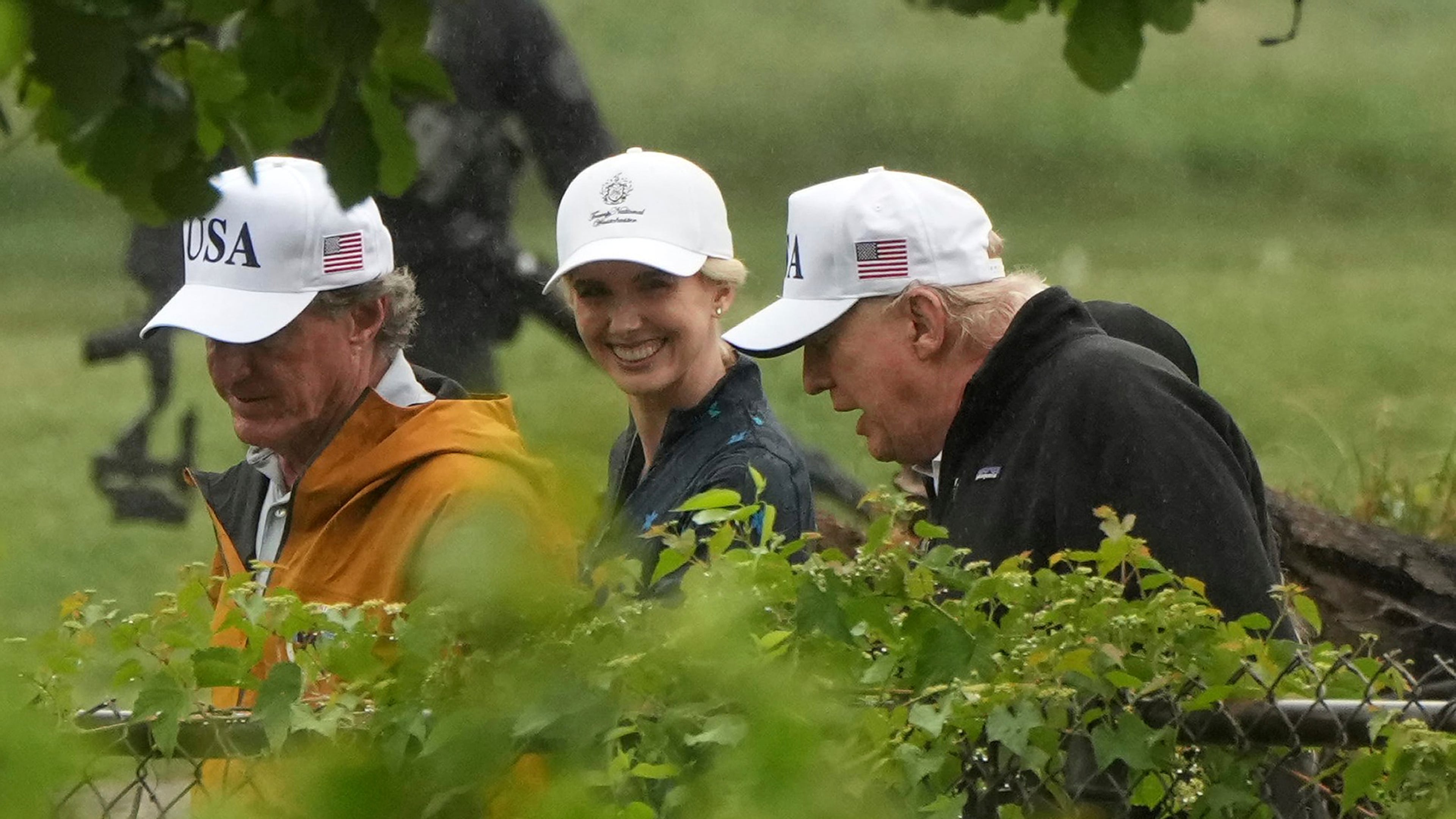 Interior Secretary Doug Burgum (left), White House aide Natalie Harp and President Donald Trump walk during a tour of the East Potomac Park golf course in June. (Mark Schiefelbein/AP)