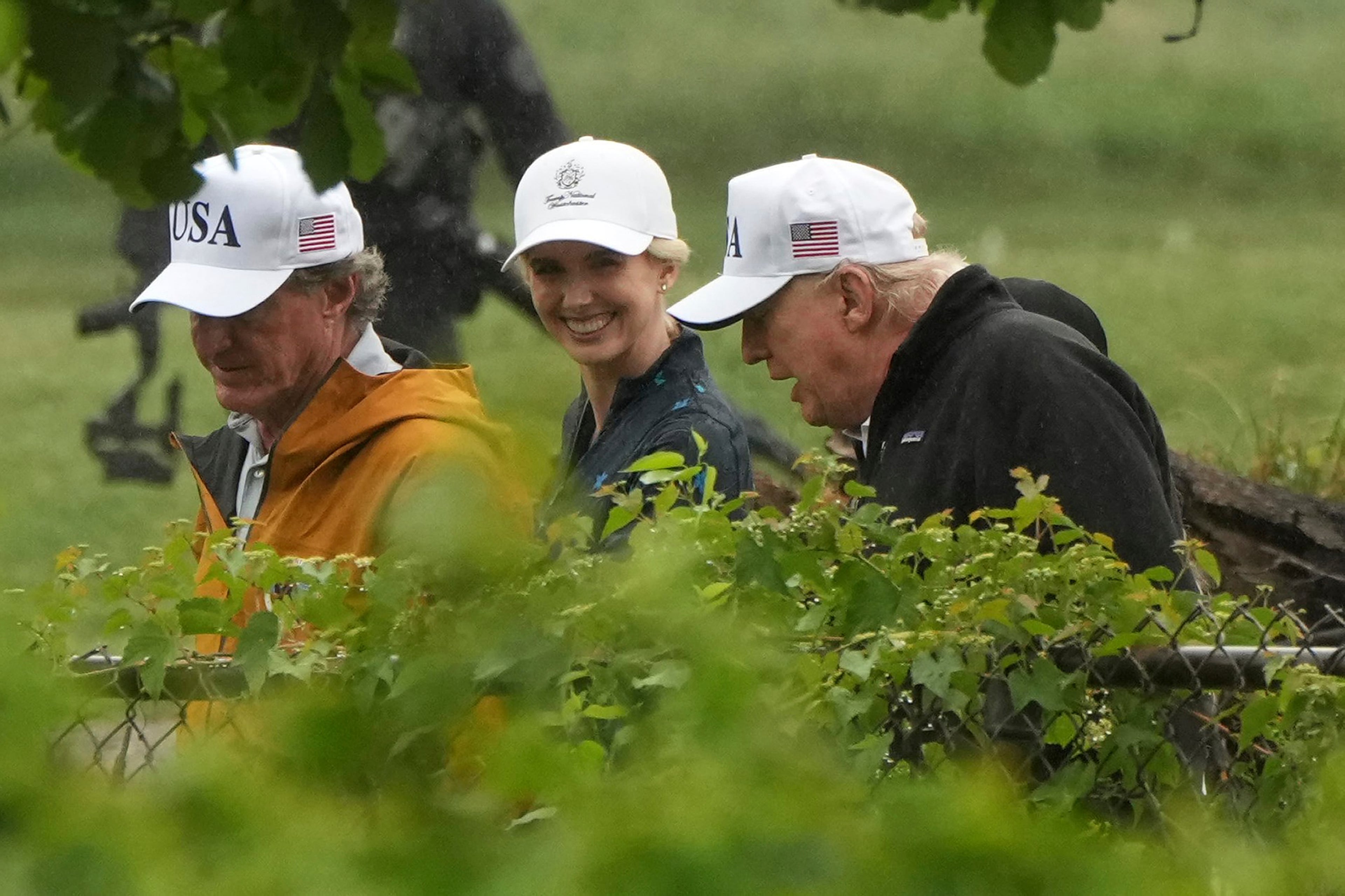 Interior Secretary Doug Burgum (from left), White House aide Natalie Harp and President Donald Trump walk during a tour of the East Potomac Park golf course in June. (Mark Schiefelbein/AP)