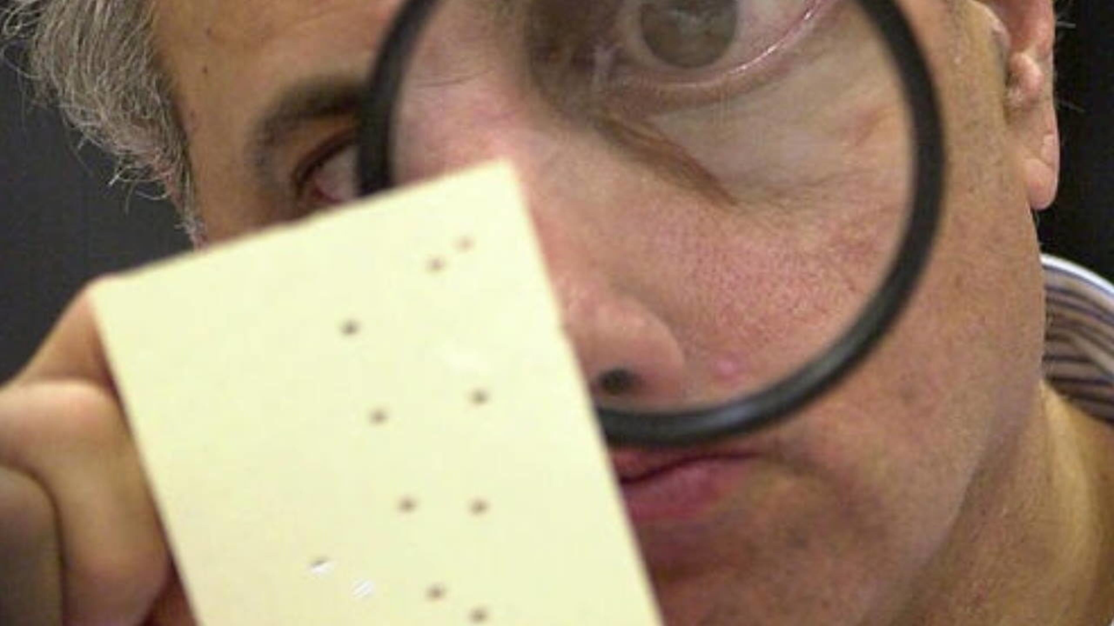 Hanging chads are not new to South Florida. In this 2000 photo, Broward Countycanvassing board member Judge Robert Rosenberg used a magnifying glass to examine a disputed ballot.