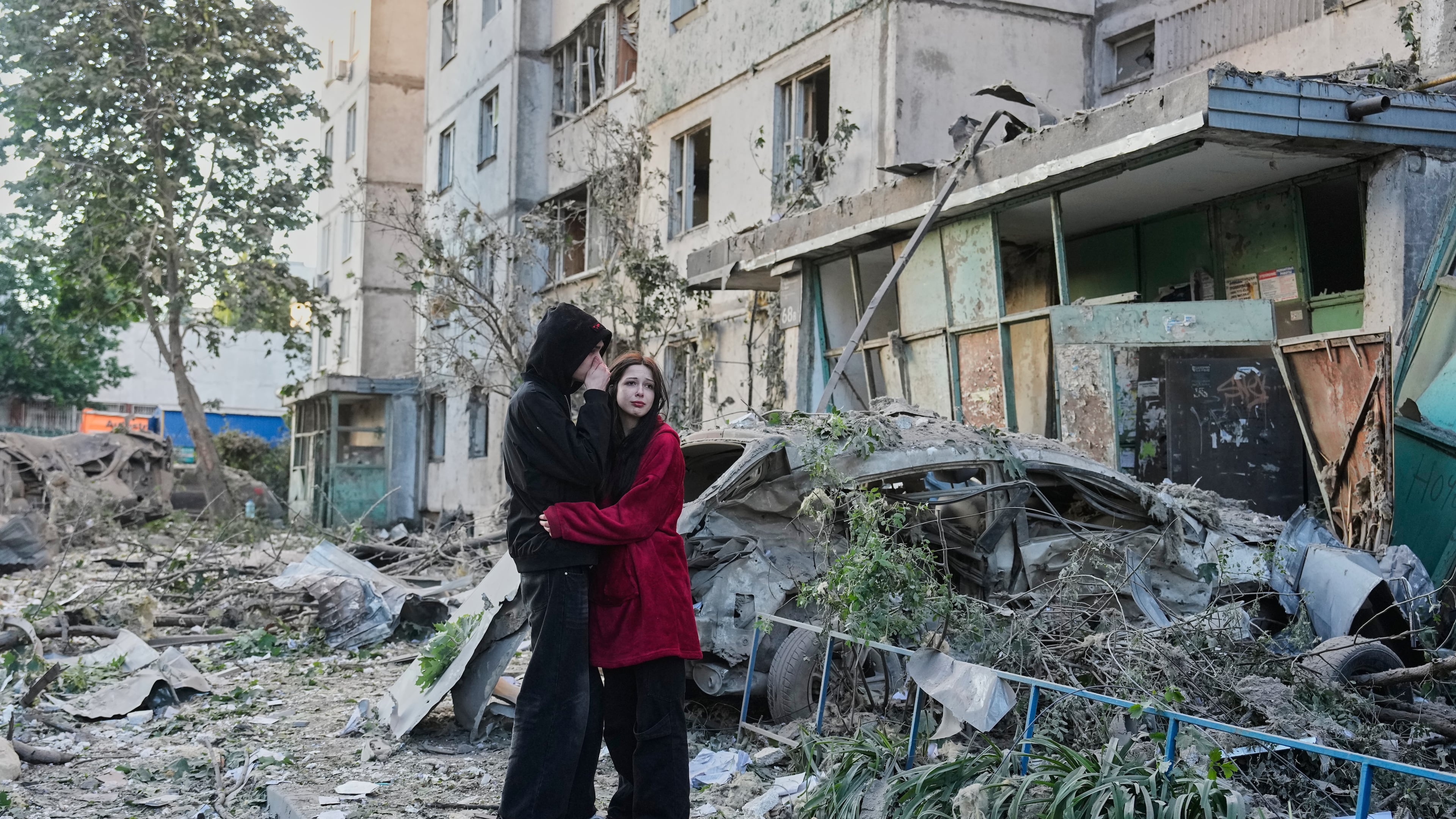 People react as they look at the site of Russian missile strike that hit a residential building in Kyiv, Ukraine, Tuesday, June 2, 2026. (AP Photo/Efrem Lukatsky)