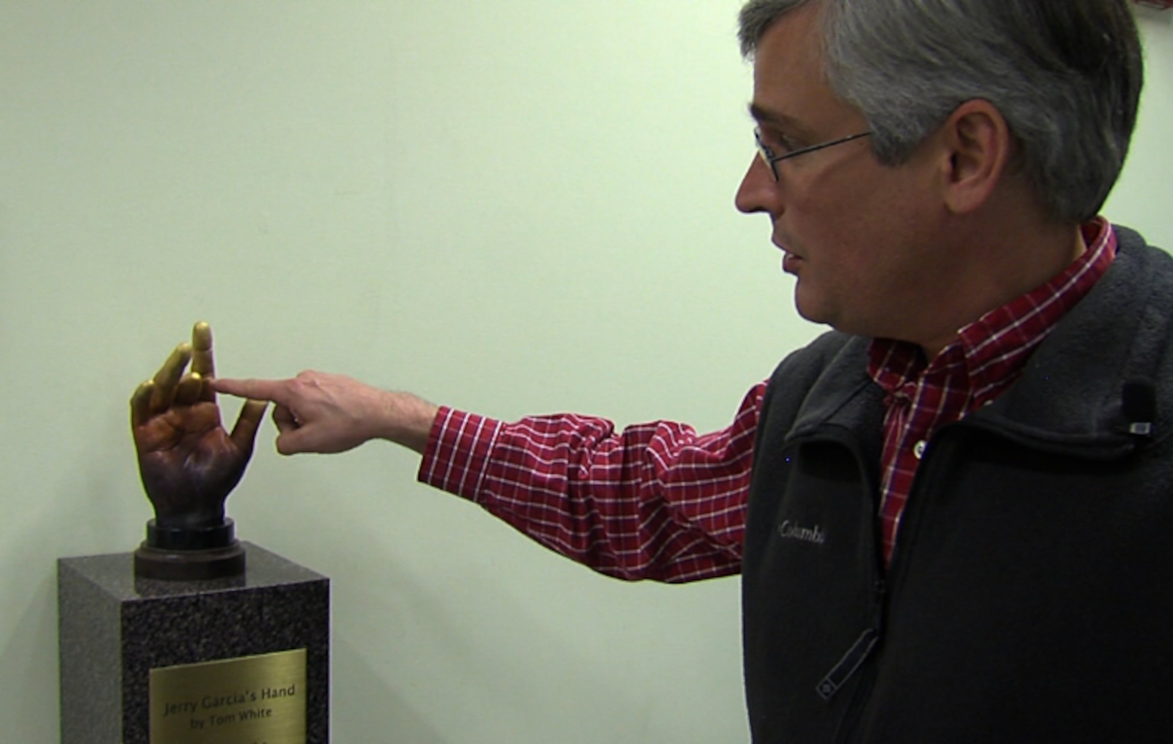 Counterculture historian Nicholas Meriwether, meticulously put together UCSC's Grateful Dead archive. Here he's standing in front of a sculpture of Jerry Garcia's hand.