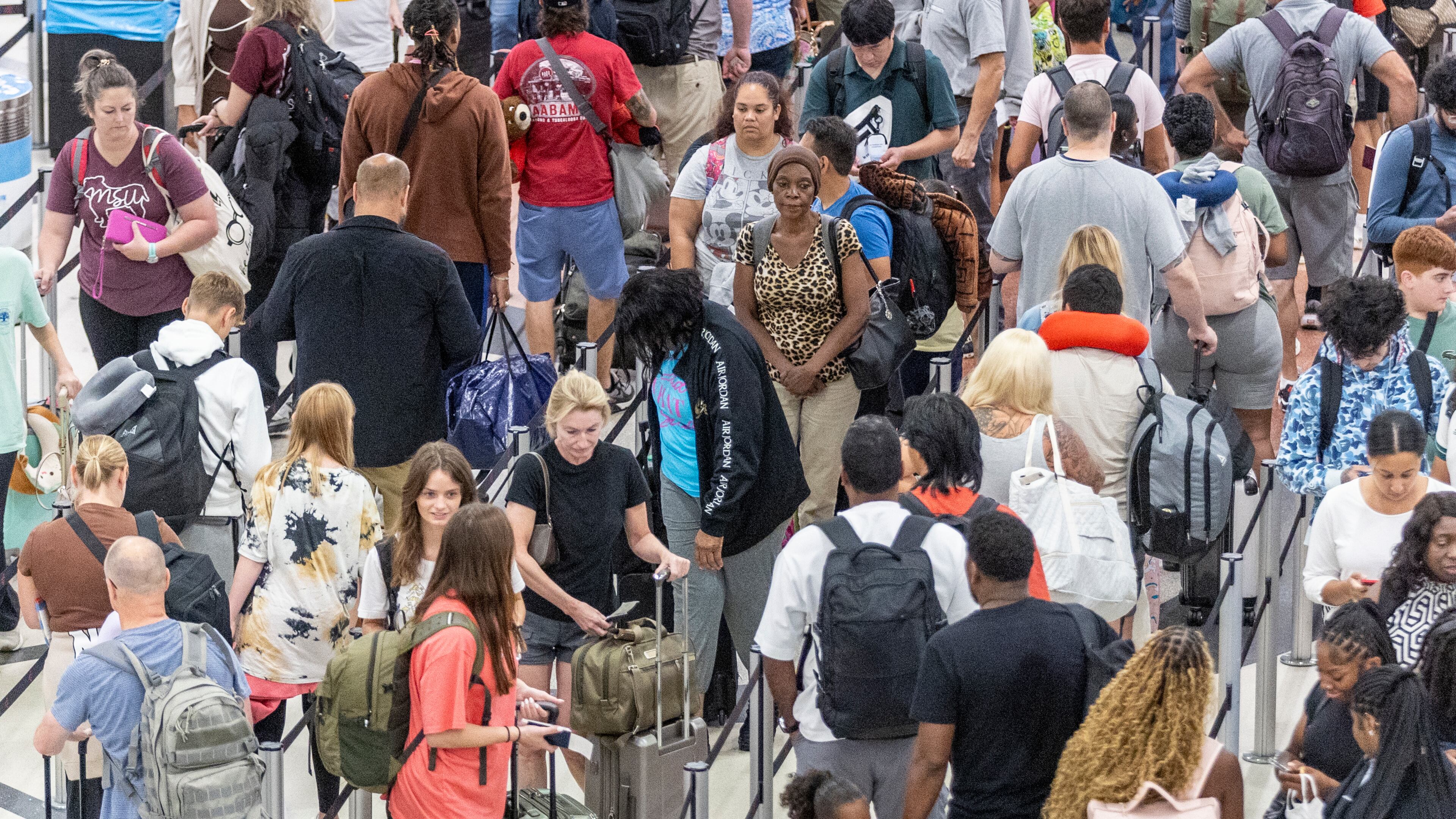 People make their way through security at Hartsfield-Jackson Atlanta International Airport Saturday after hundreds of airline flights were canceled due to a global technology outage. (Steve Schaefer / AJC)