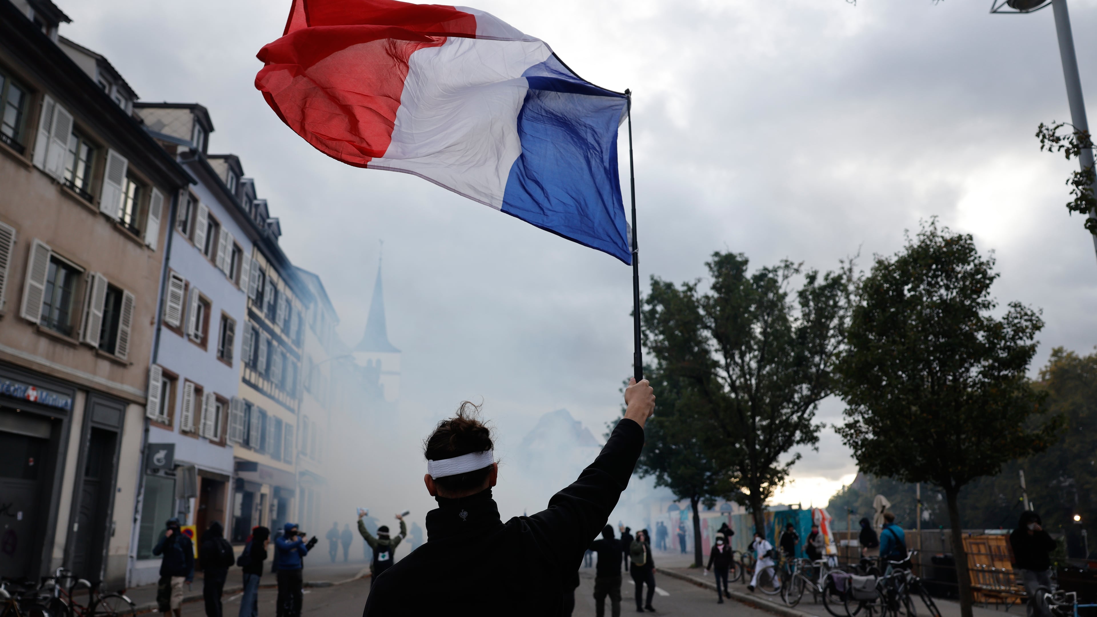 A protester holds a French flag during a demonstration against rising living costs in Strasbourg, France, Saturday, Oct. 24, 2026. (AP Photo/Jean-Francois Badias)