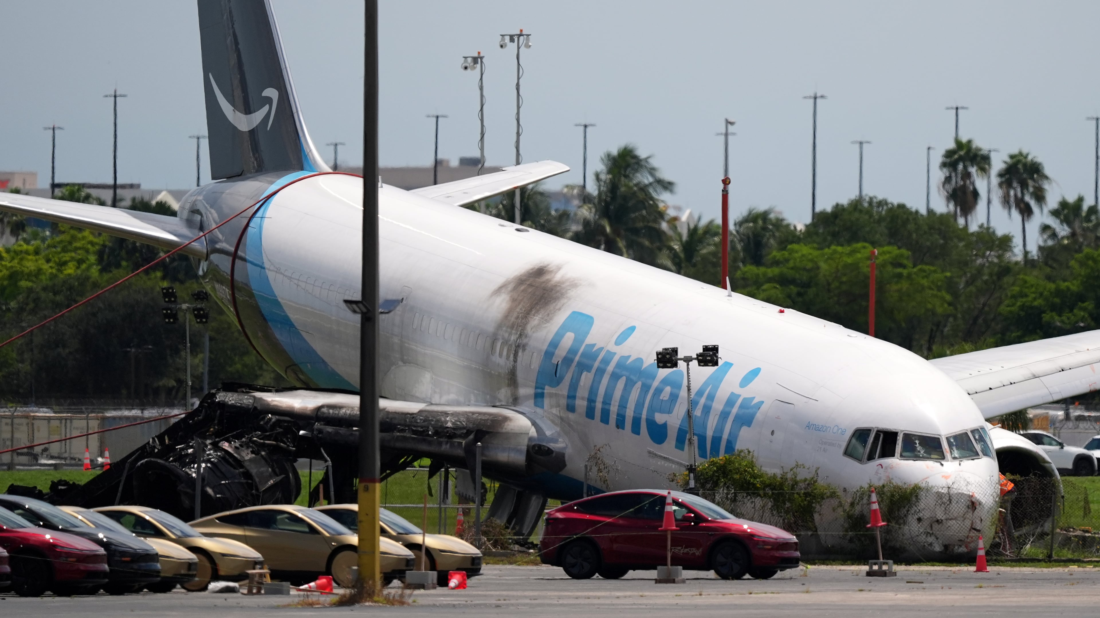 An Amazon cargo plane lies damaged near a parking lot two days after overshooting a runway at Miami International Airport, Tuesday, Sept. 8, 2026, in Miami. (AP Photo/Rebecca Blackwell)